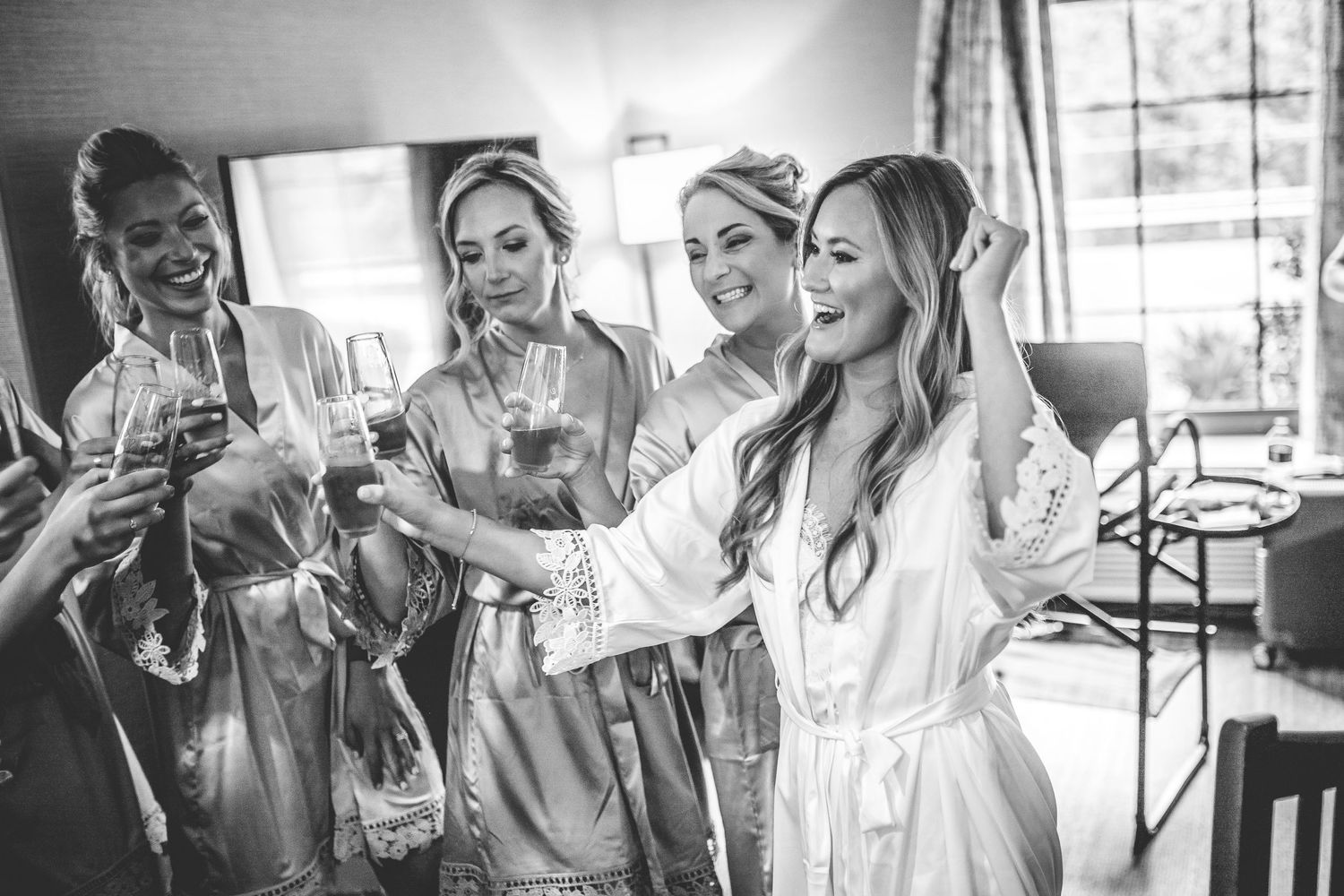 Wedding party members in white robes celebrating during pre-ceremony preparations.