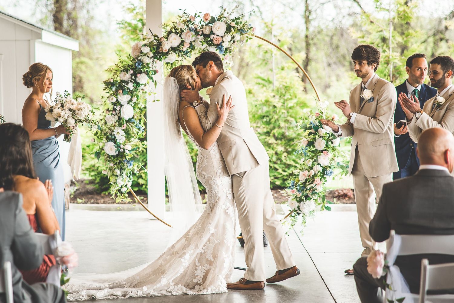 Wide view of wedding ceremony with guests seated in rustic indoor venue.