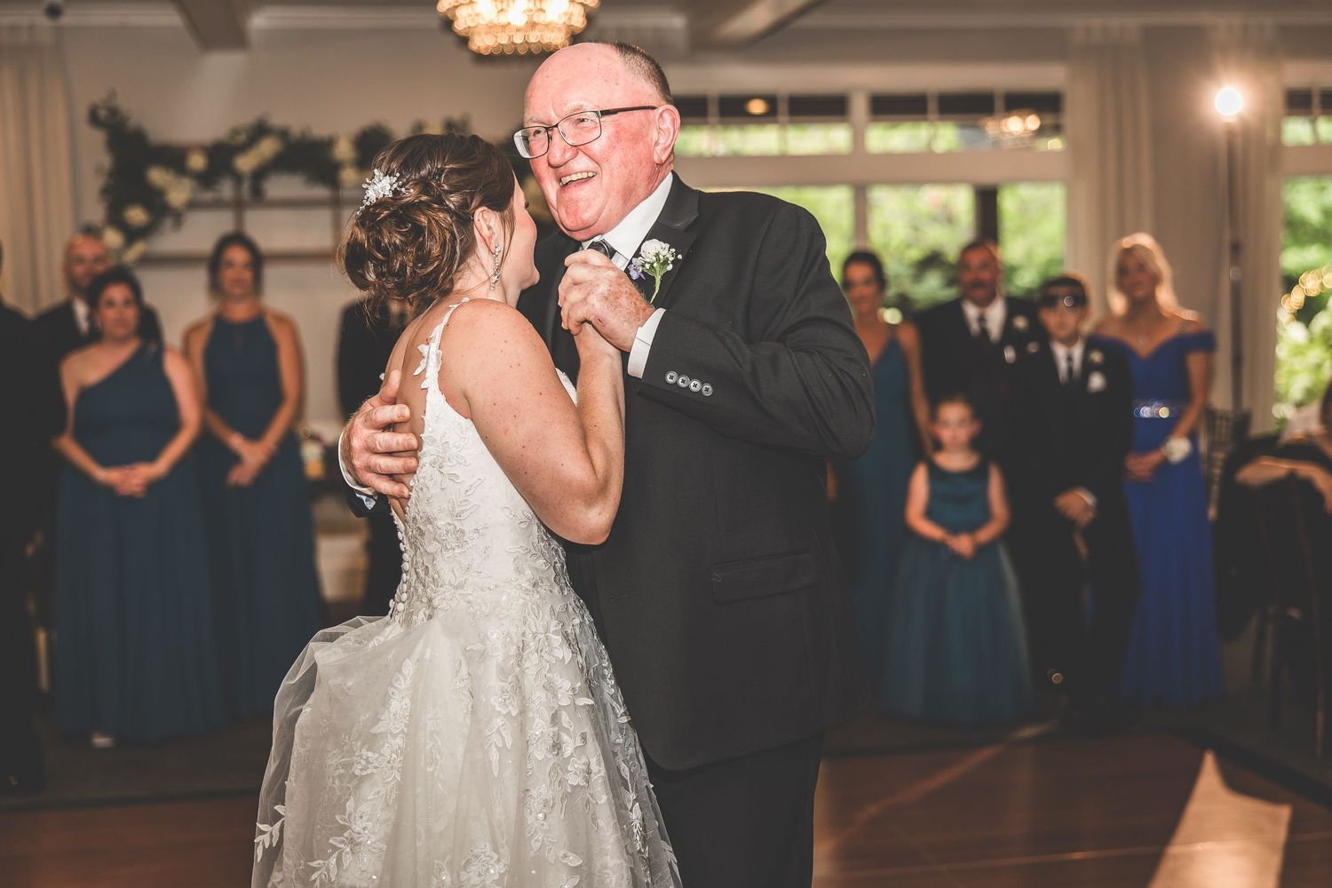Couples dancing together at a formal wedding reception under warm lighting.
