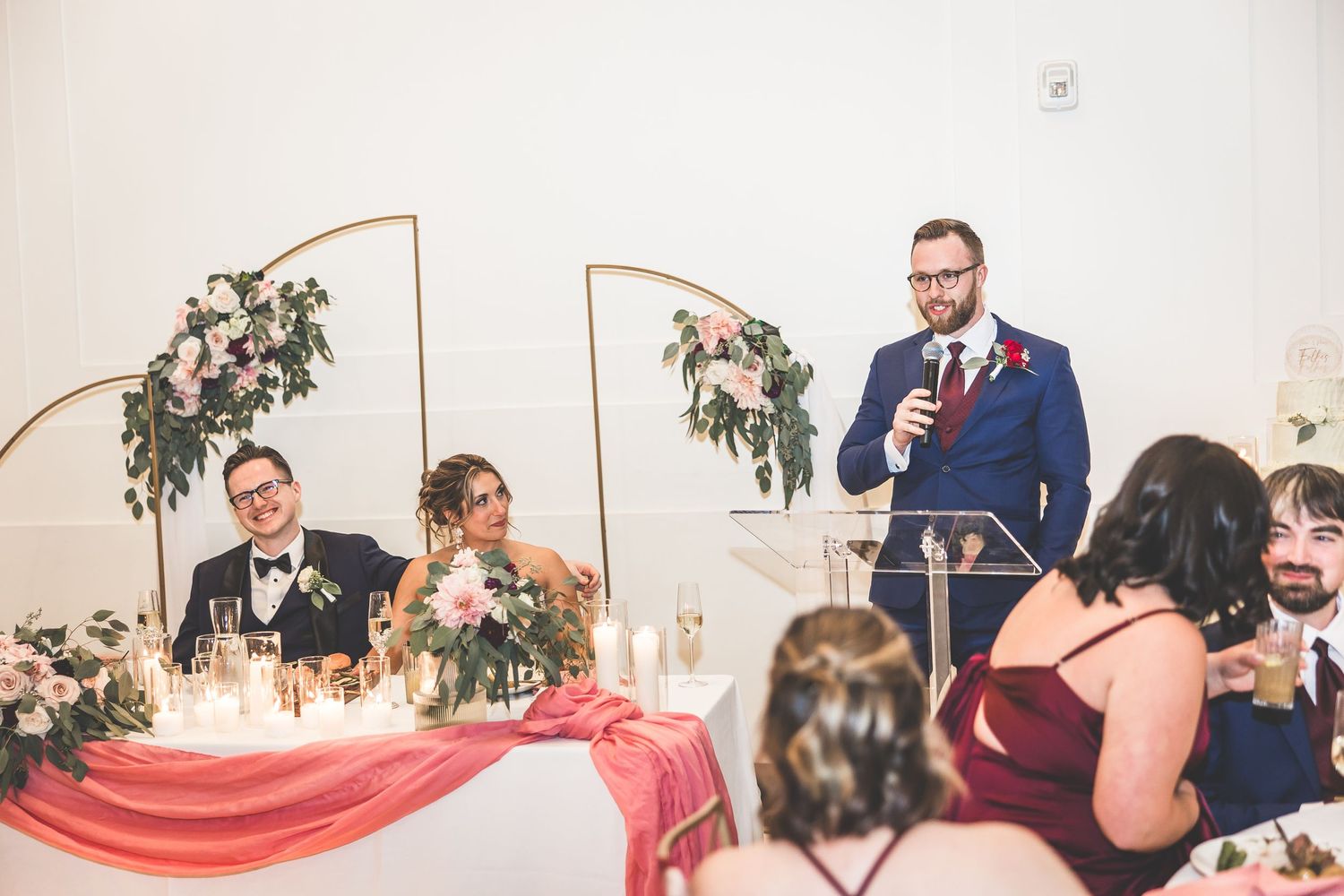 Wedding celebration with guests seated at decorated tables during evening reception.