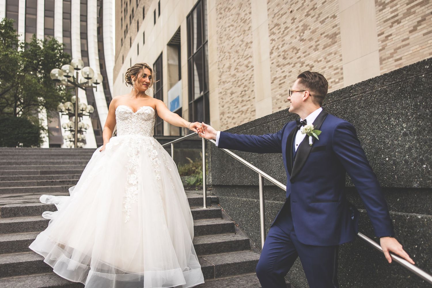 Newlyweds create romantic poses on outdoor steps of a downtown building.