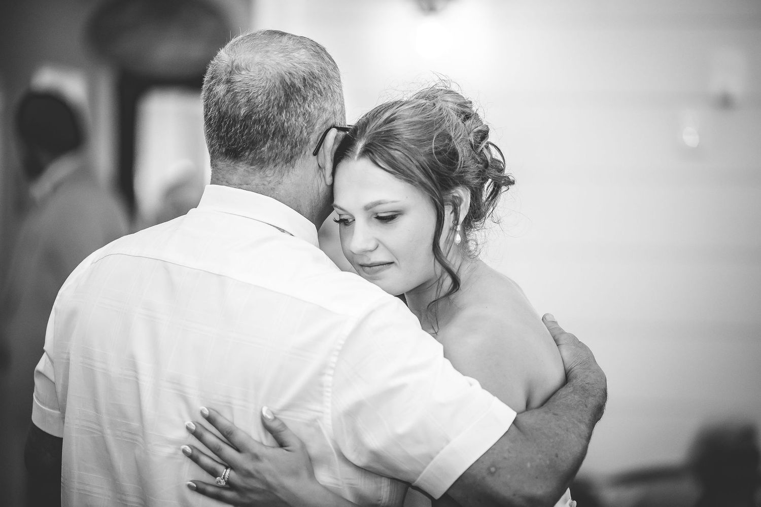 Intimate black and white photo of couples slow dancing at a wedding reception.