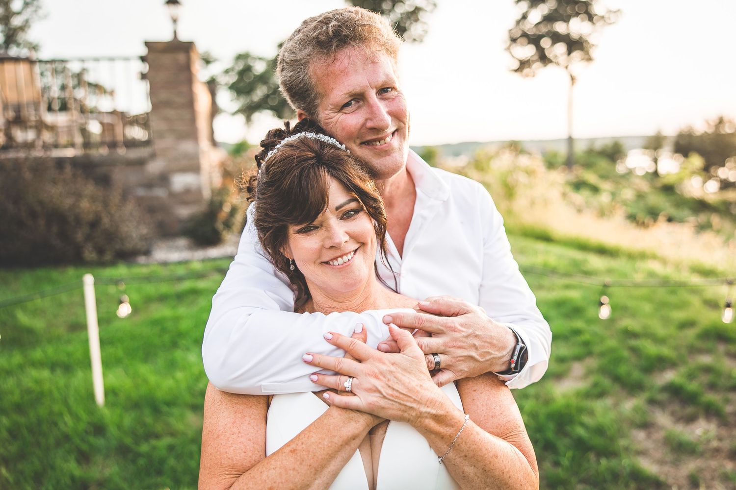 A couple shares an intimate moment while embracing in golden evening light.
