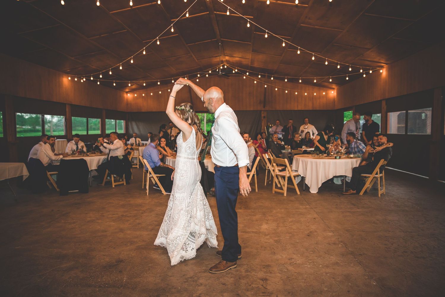 A romantic dance scene at a wedding reception with string lights creating a warm ambiance.