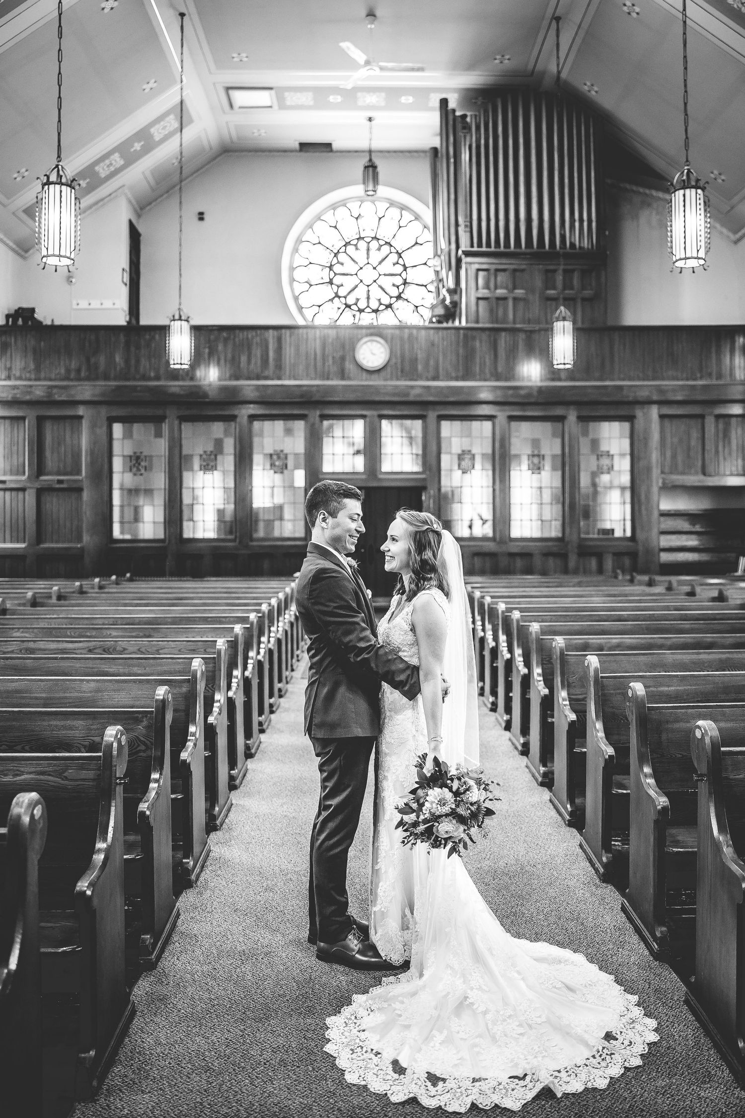 Church wedding photos showing couple in aisle with wooden pews and organ pipes in background.