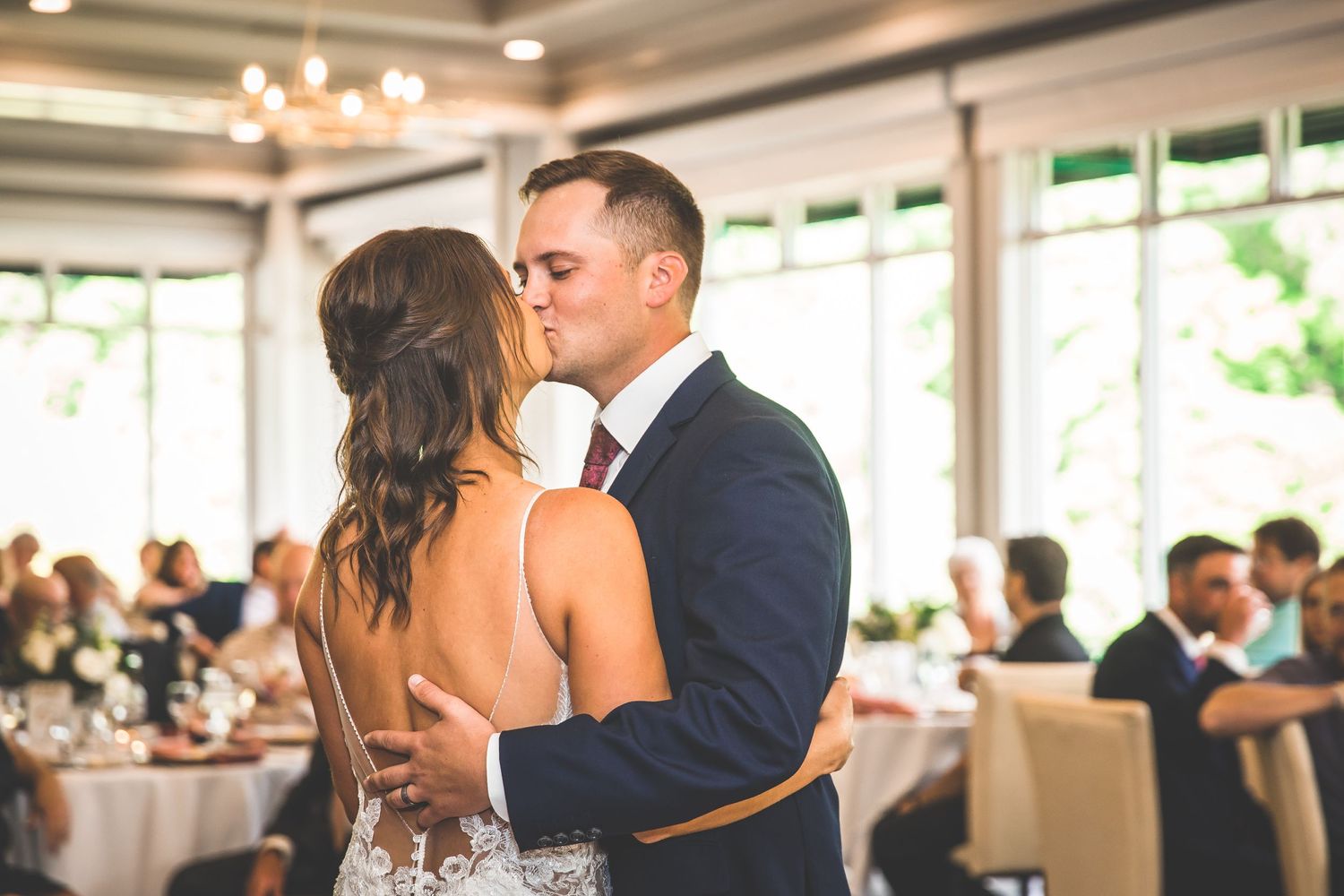 Intimate dance moment at an elegant wedding reception with natural lighting.