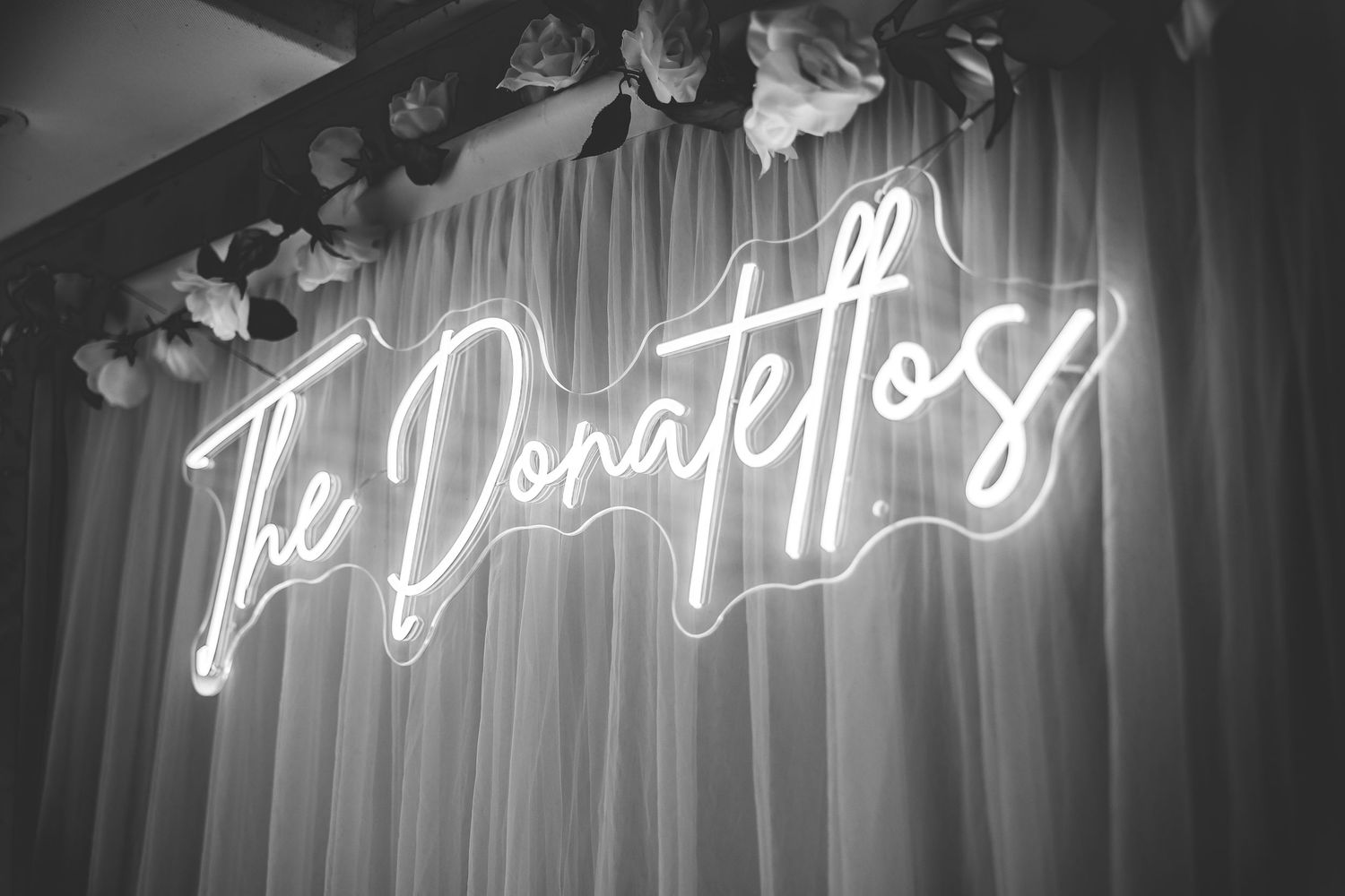 Elegant neon script wedding signs glowing against a dark background create a romantic ambiance.
