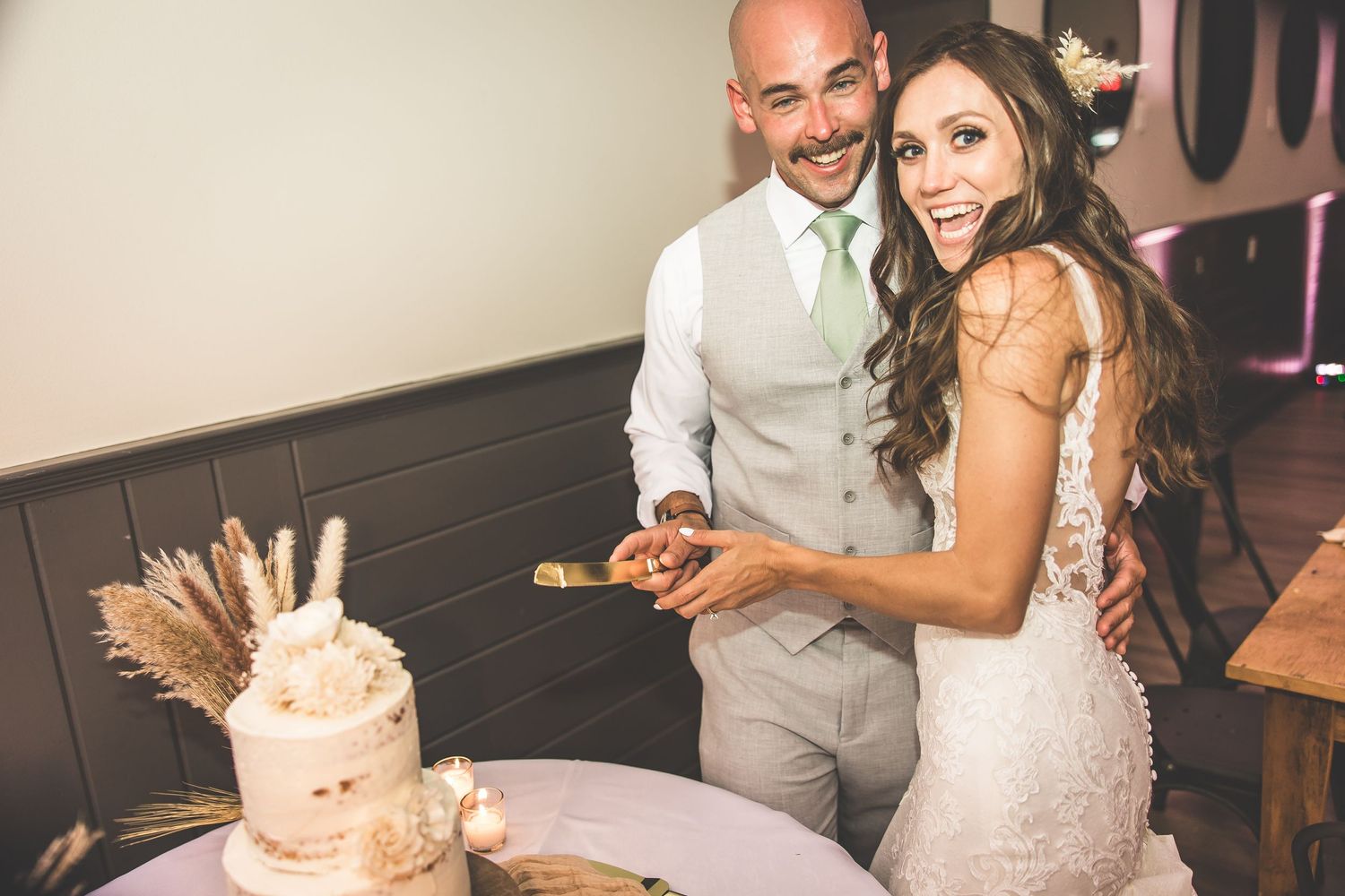 Couple sharing a romantic moment with wedding cake during their reception celebration.