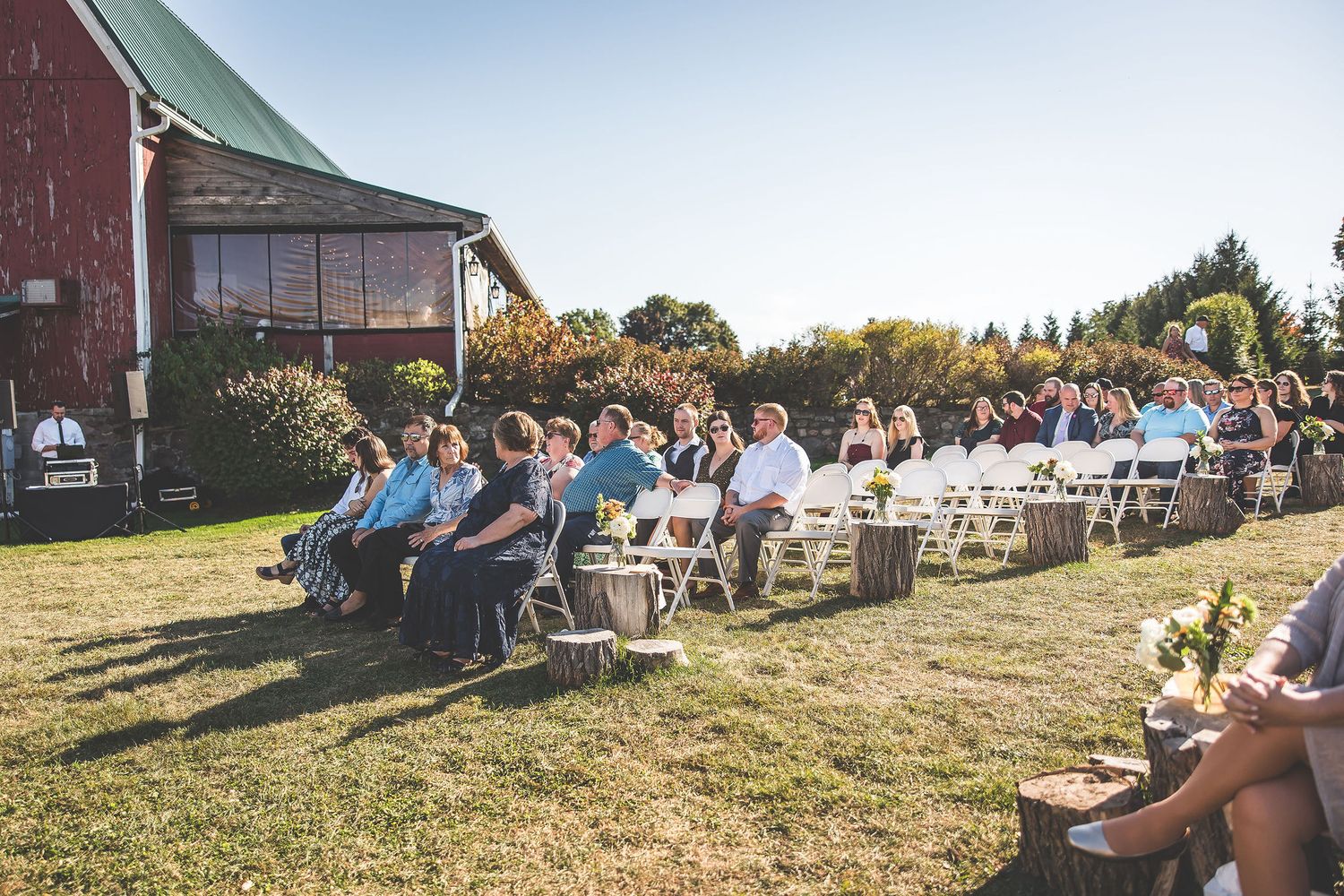 Wedding ceremony setup with chairs on hillside overlooking scenic farm landscape.