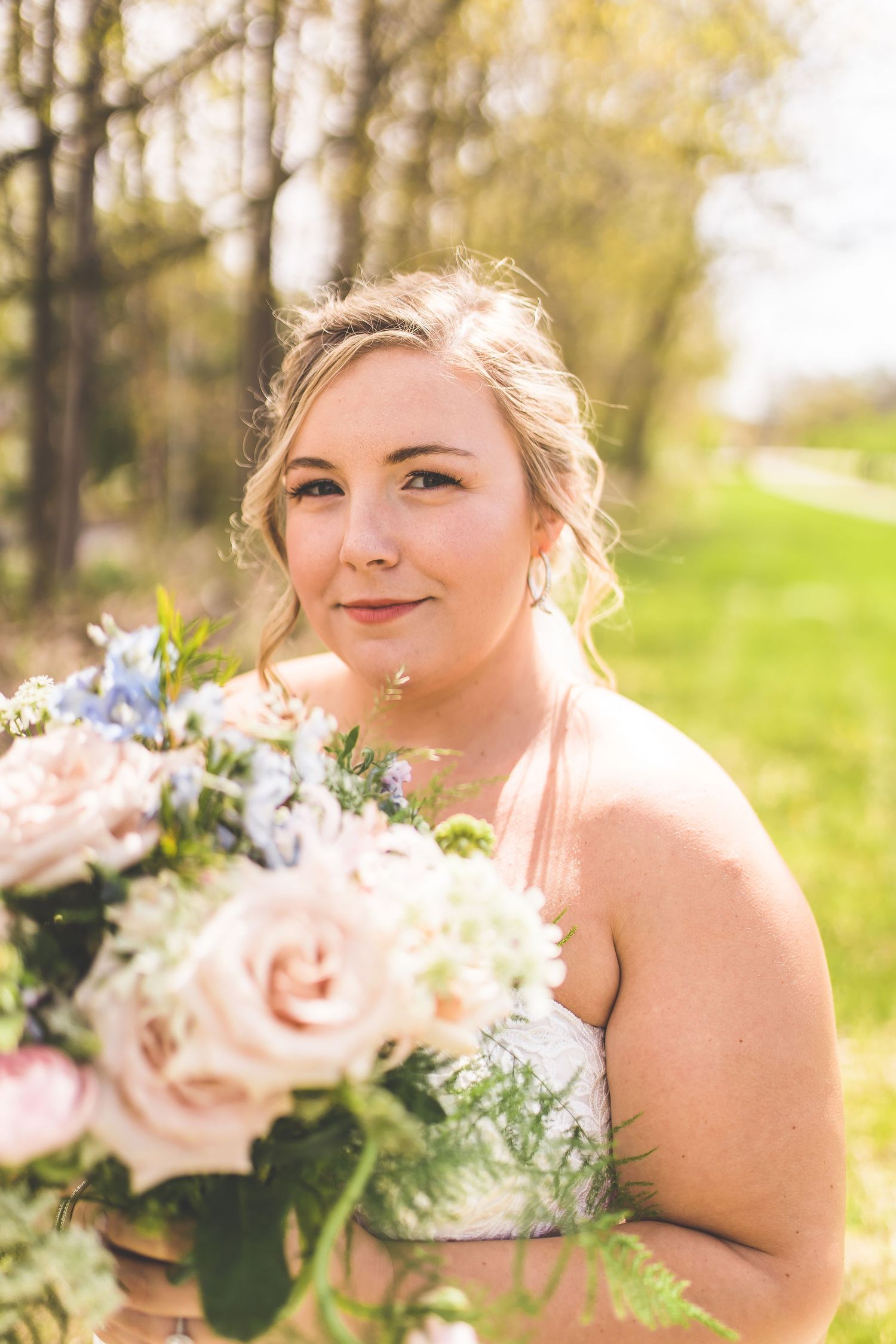 Soft portrait with pink roses and delicate spring flowers in natural lighting.