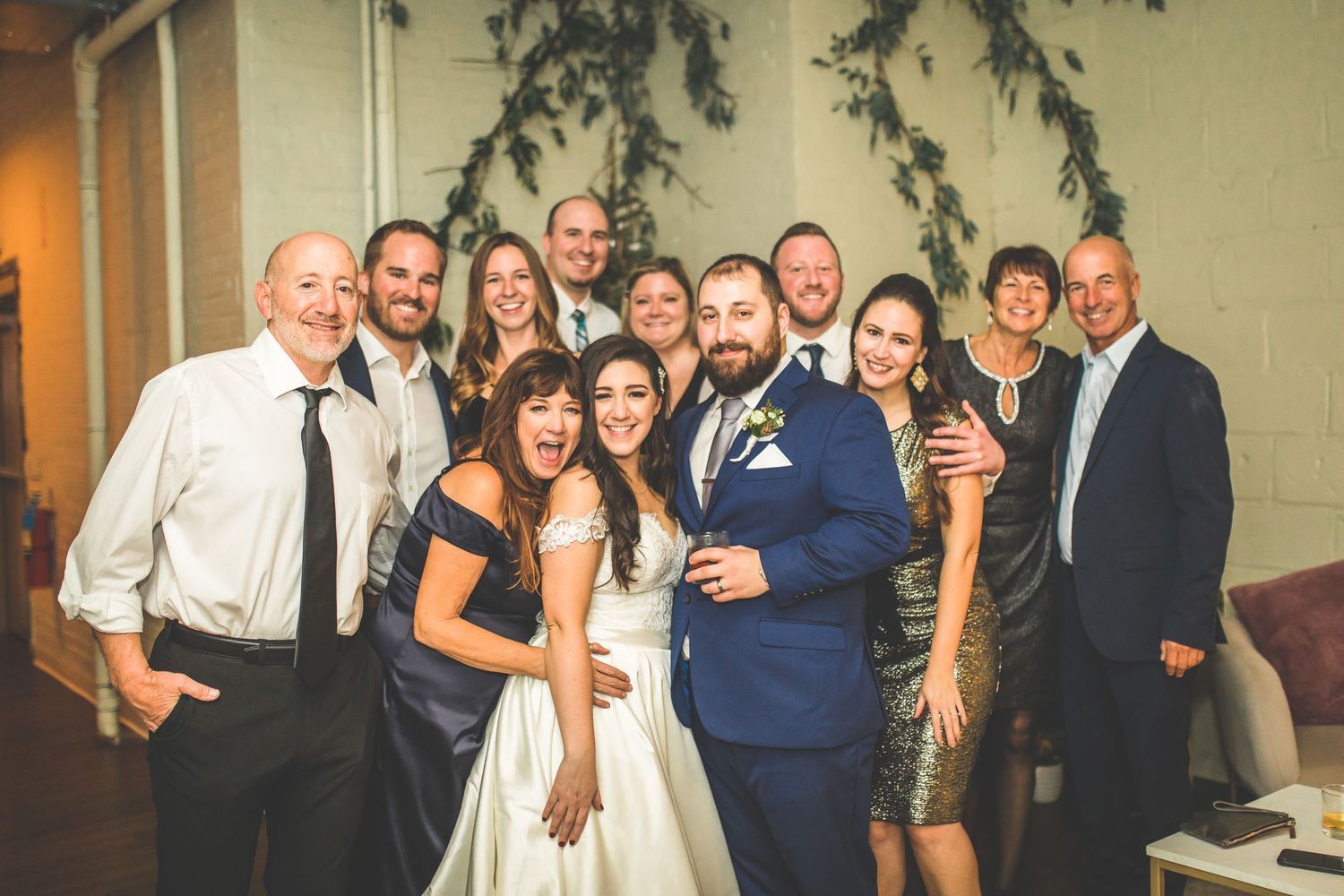 Wedding reception group photo with guests gathered for formal pictures.