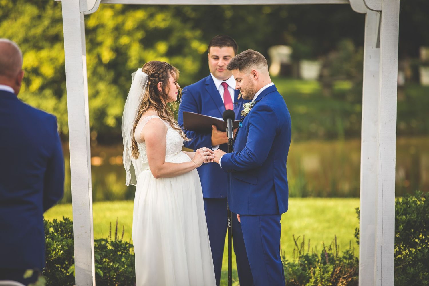 Intimate wedding ceremony moments under a decorative white pergola.