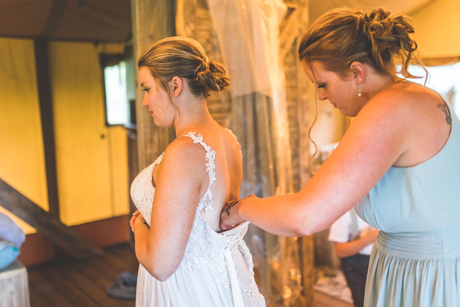 Wedding party getting ready in a rustic room with yellow walls.