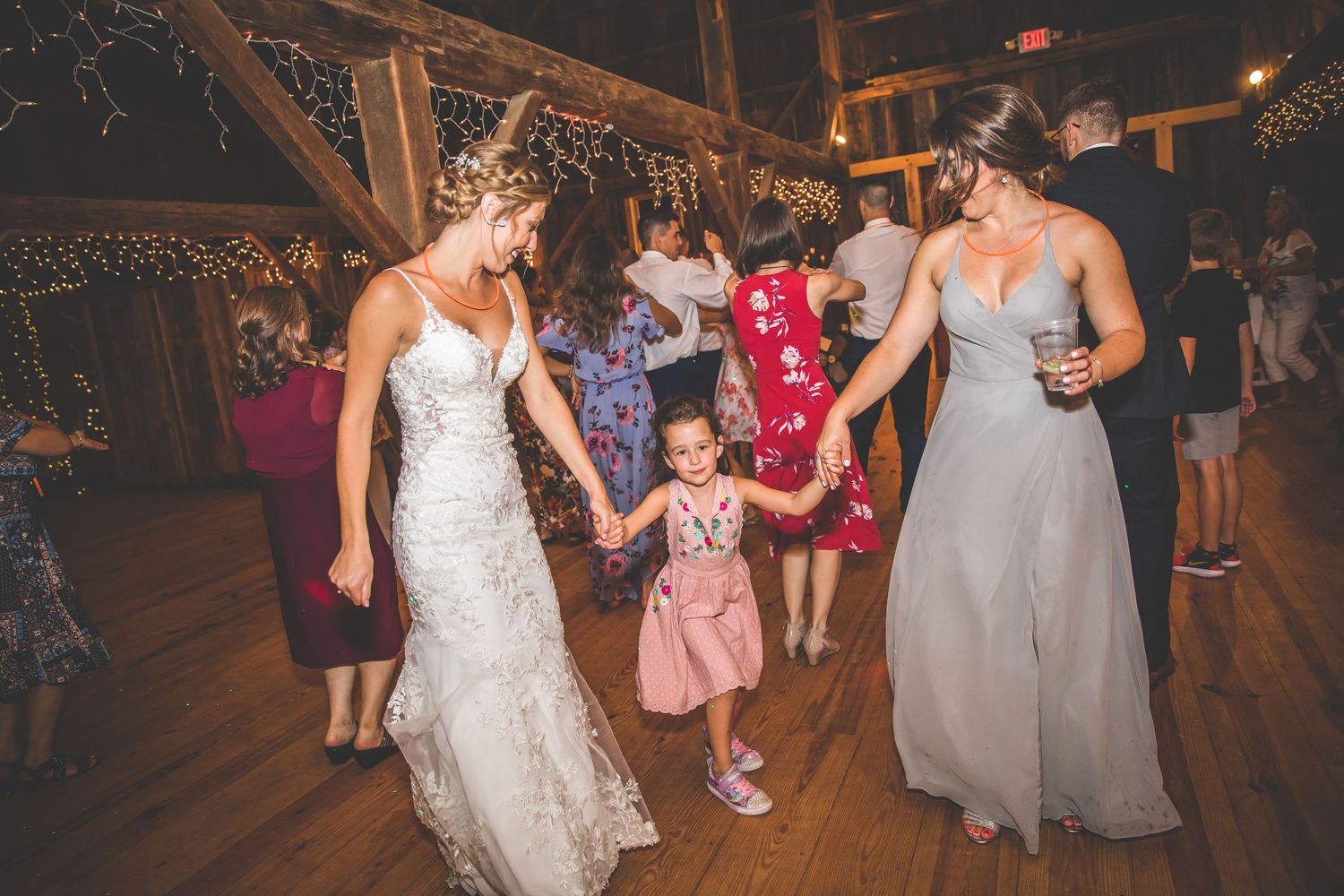 Guests enjoying a lively dance party at a rustic barn wedding reception.
