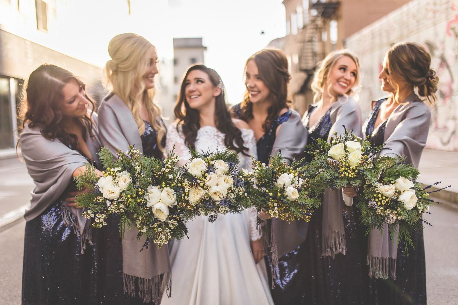 Candid moment of bridal party celebrating together on city street.