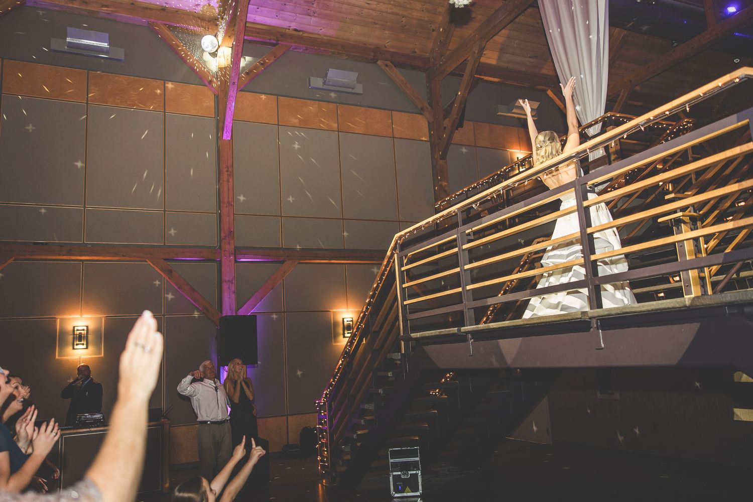 Energetic dance party scene with guests enjoying themselves under purple venue lighting.
