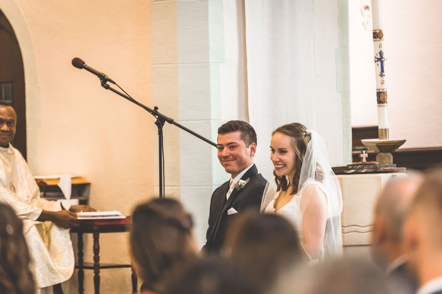 Wedding ceremony taking place at the altar of a traditional church with white columns.