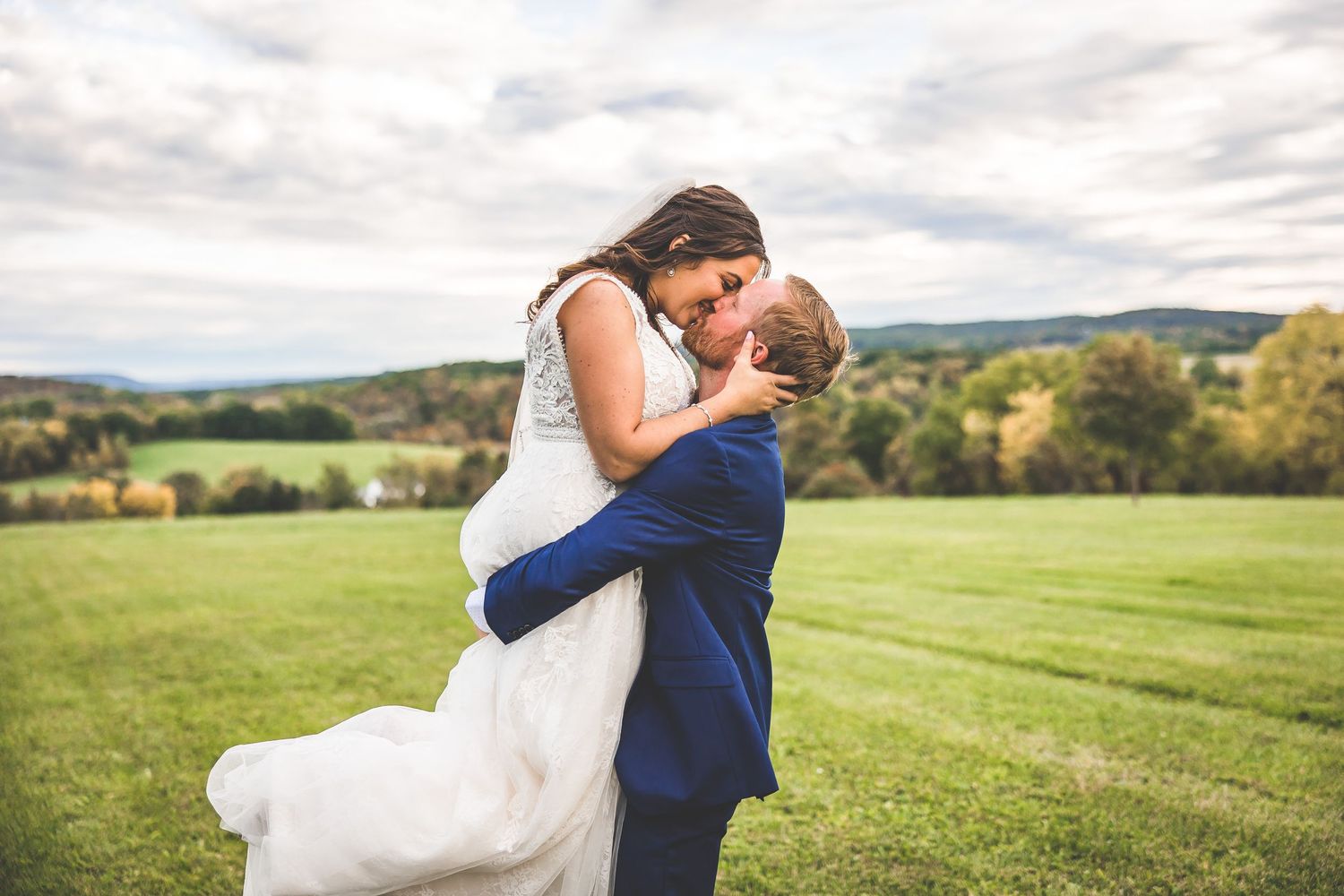 Elegant wedding photography captures intimate moments against a backdrop of rolling countryside hills.