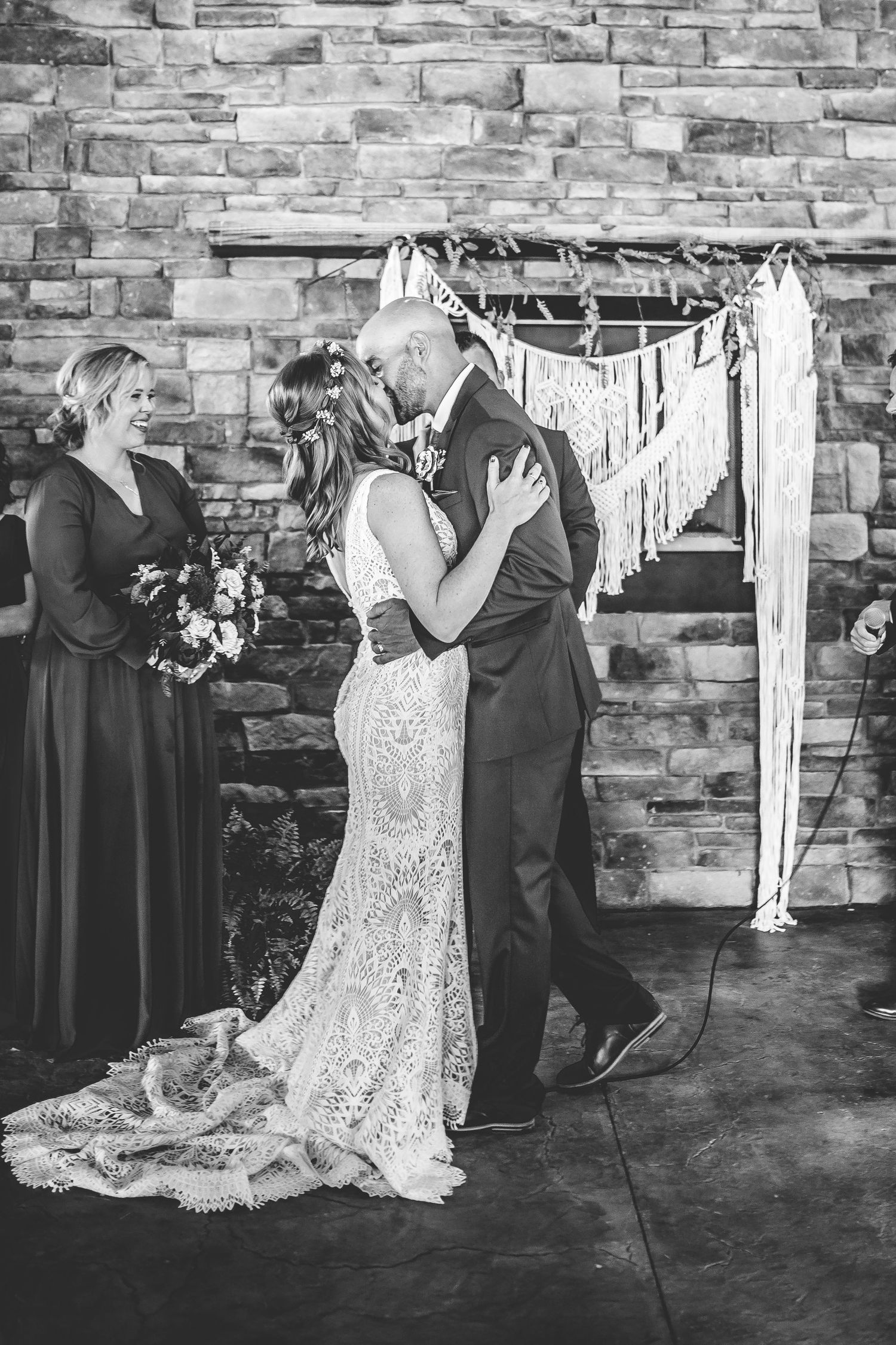 Black and white wedding photos showing emotional ceremony moments against stone wall.