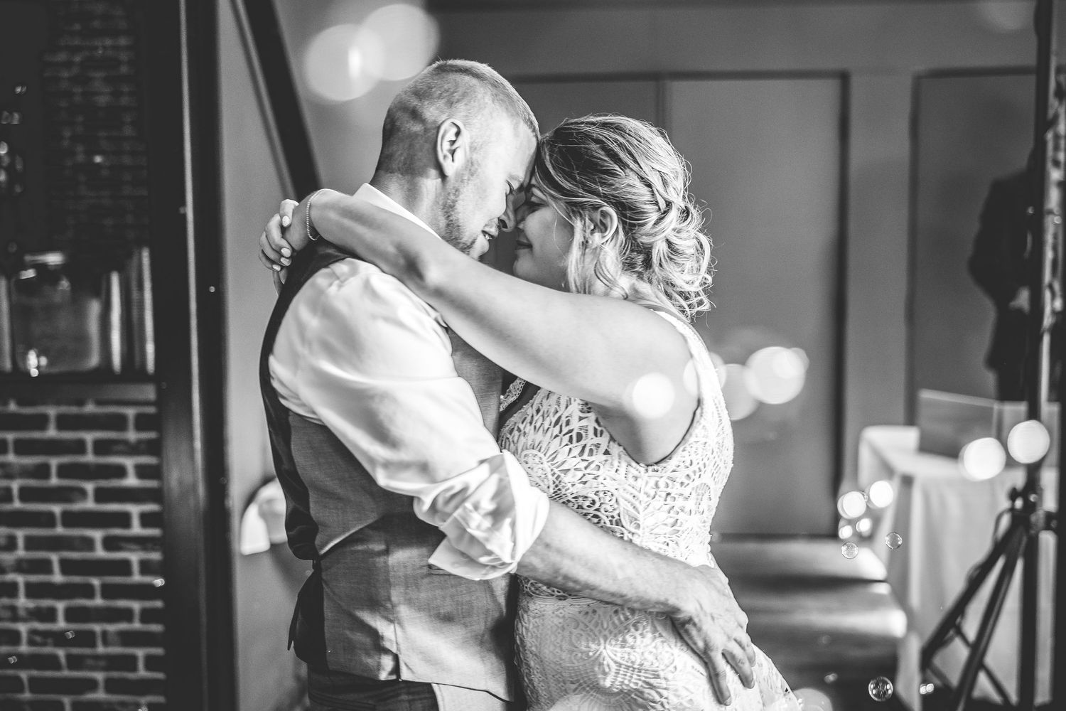 Romantic dance moments captured in black and white at an indoor wedding reception.