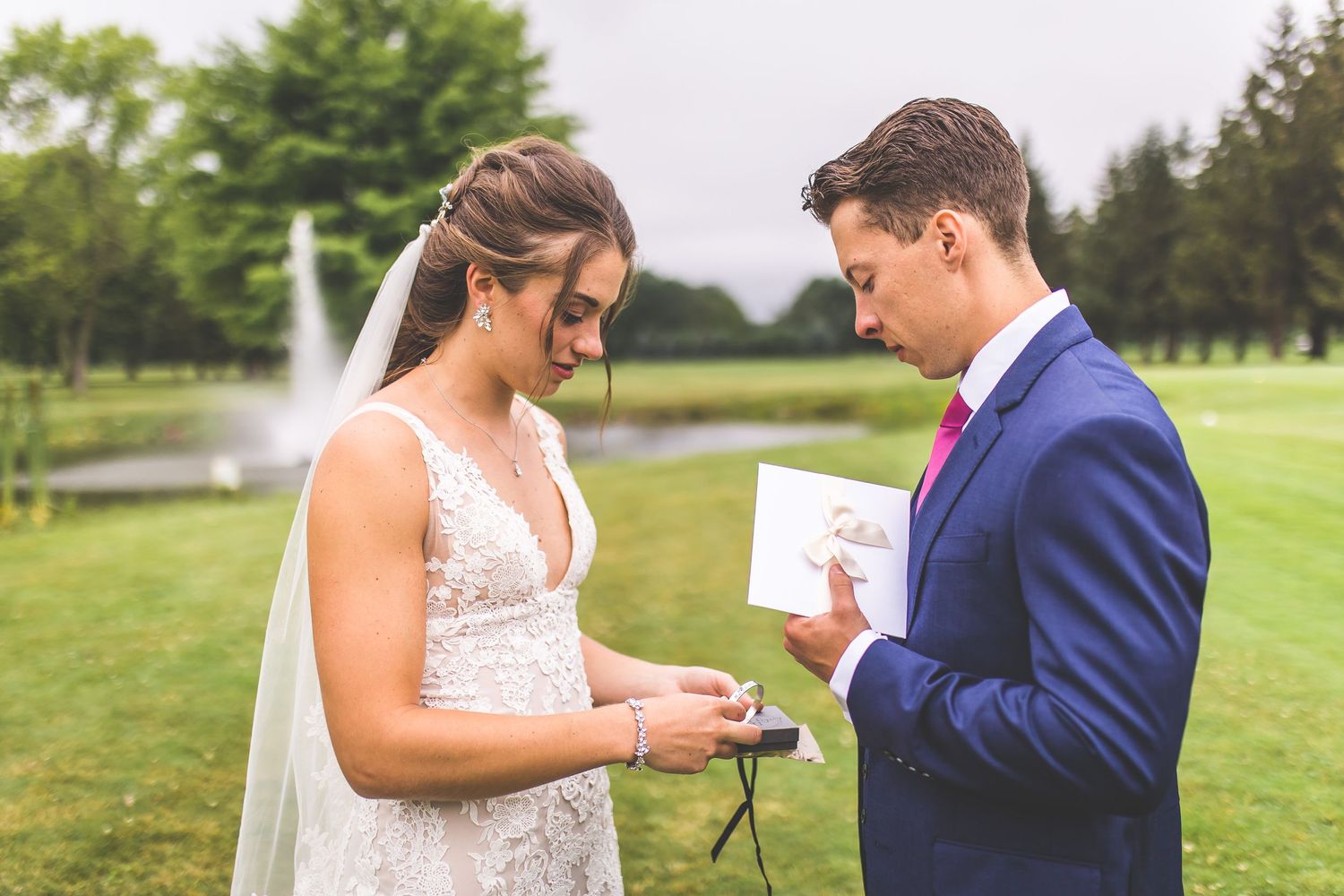 A couple exchanges handwritten vows during their outdoor wedding ceremony.