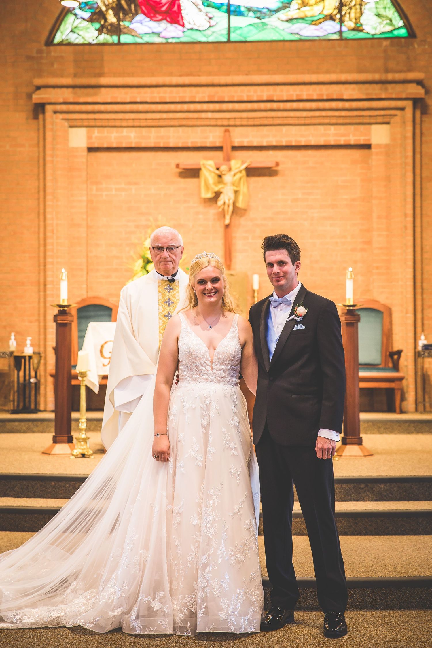Wedding ceremony with couple and attendants in traditional church setting.