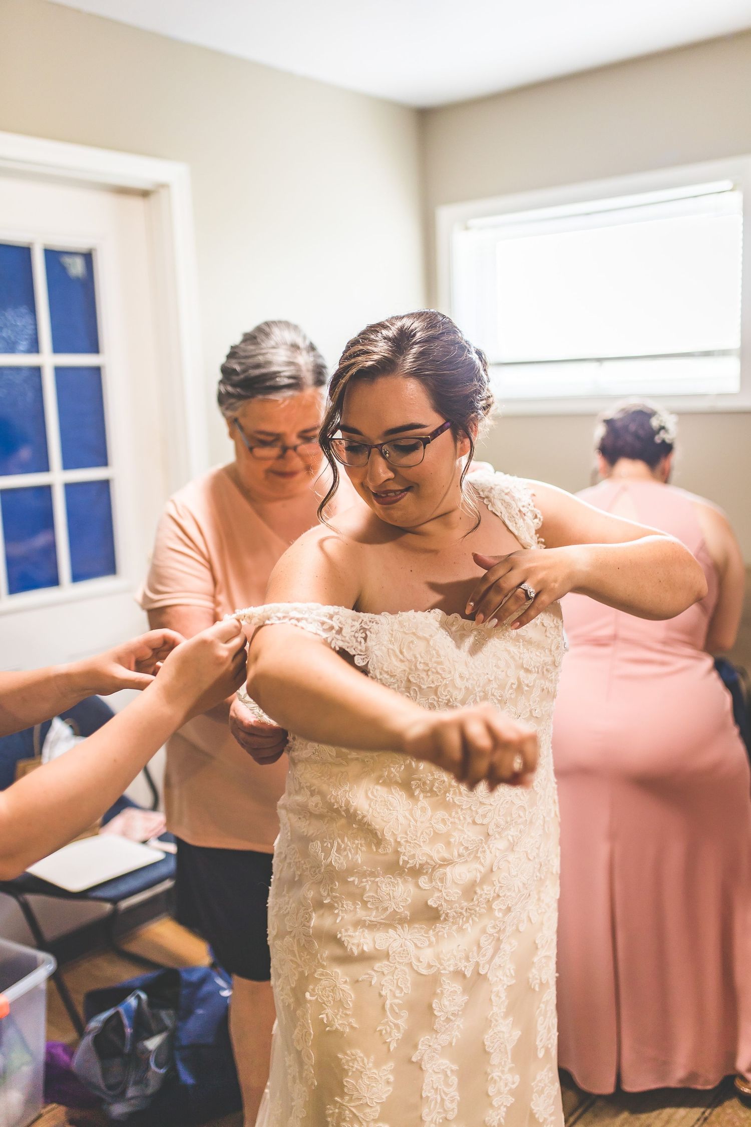 Wedding preparation scene in bright room with white walls and natural light.