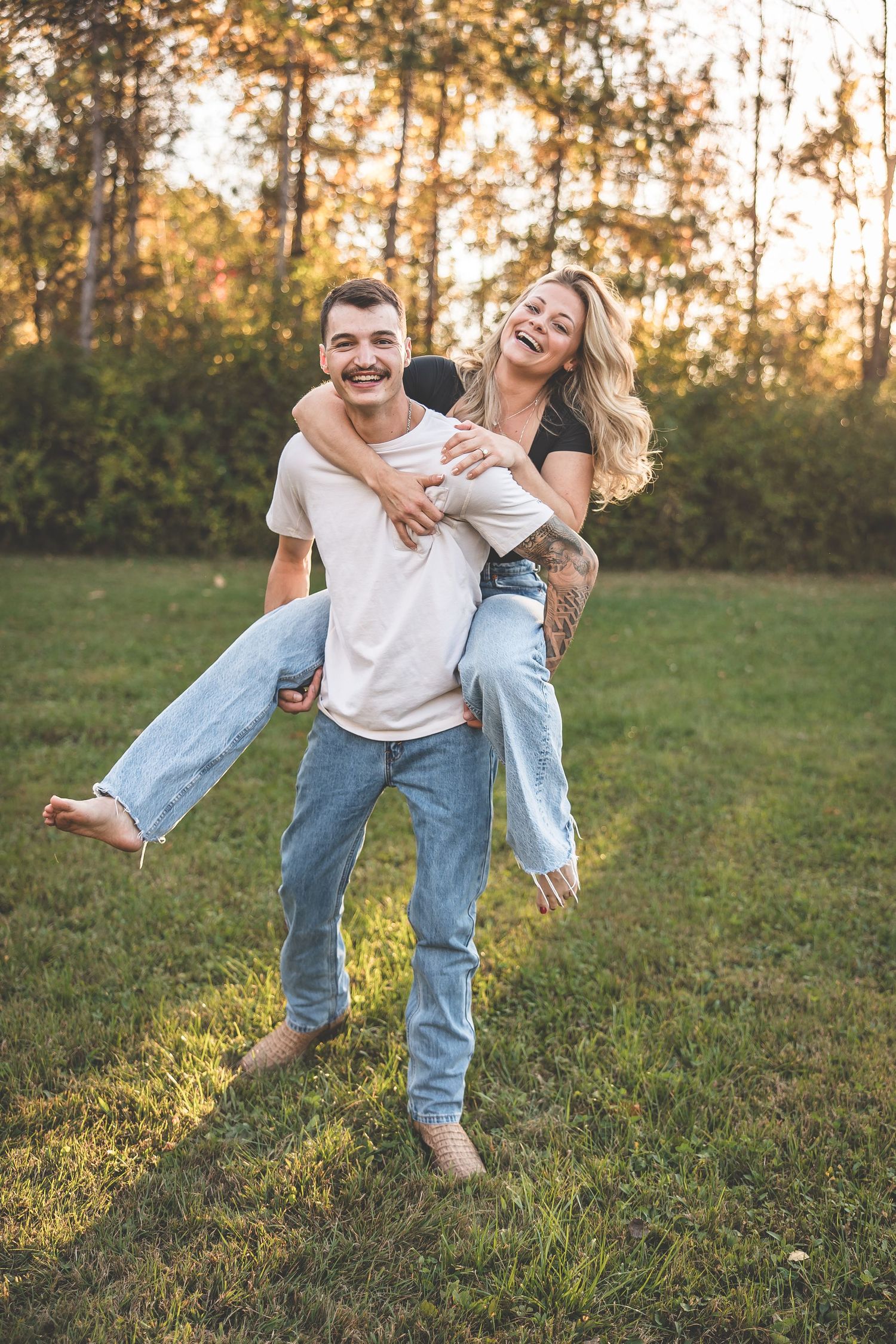 Playful piggyback ride in a grassy field during golden hour sunset.