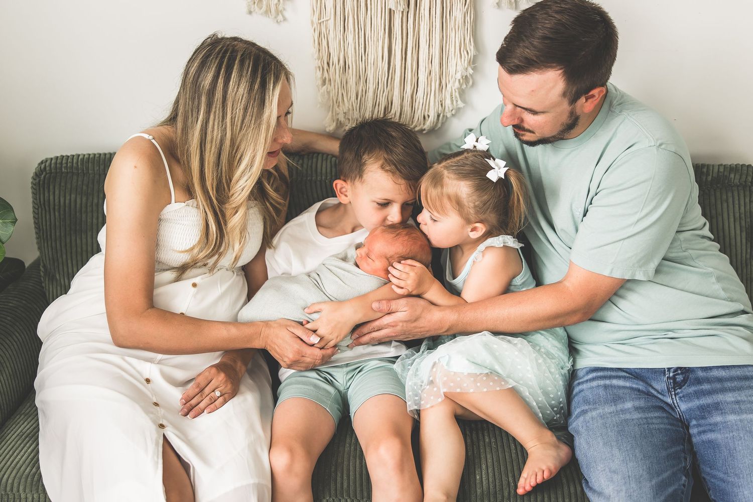A cozy indoor family portrait session on a cream-colored couch.