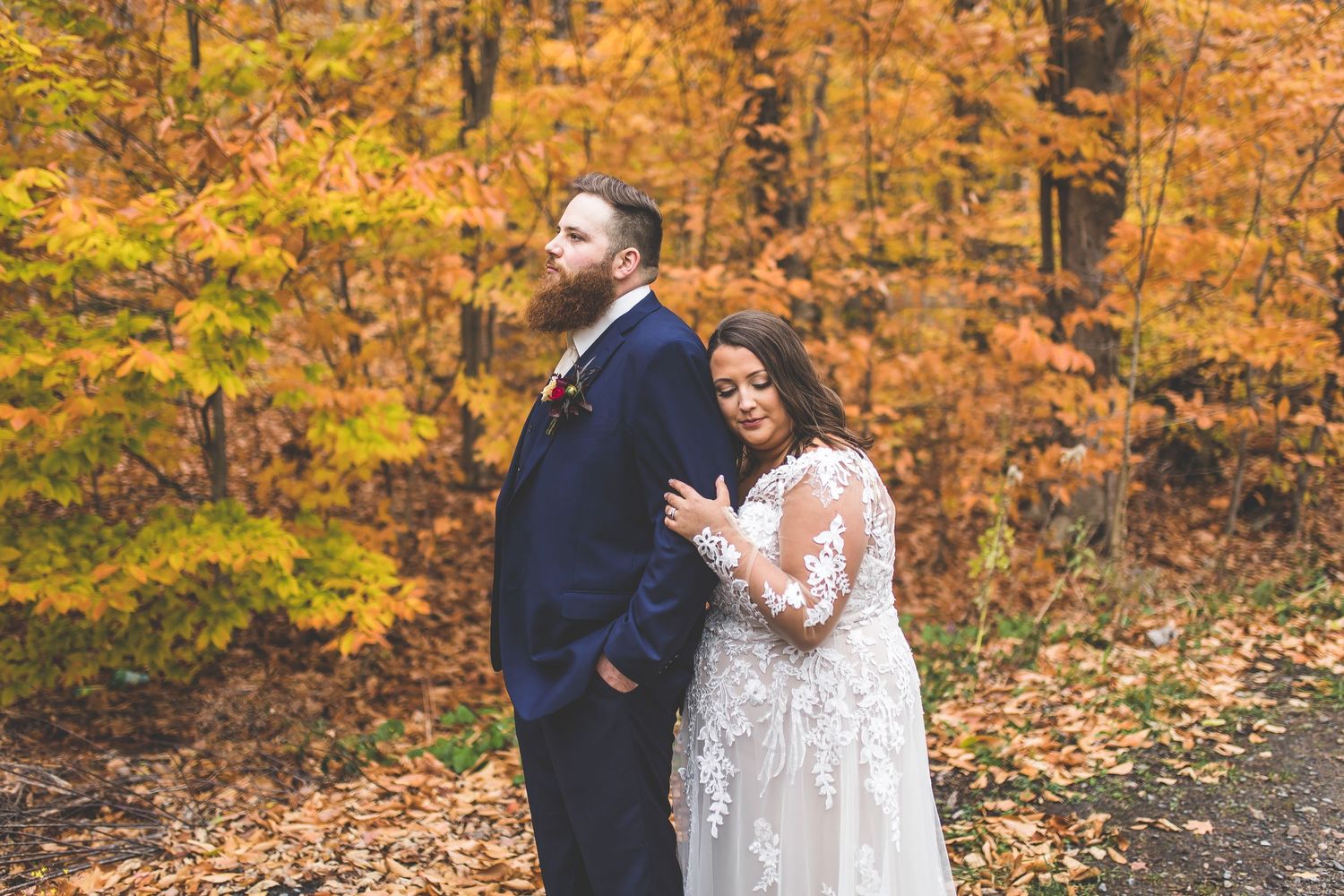 A romantic autumn wedding moment captured with golden leaves in the background.