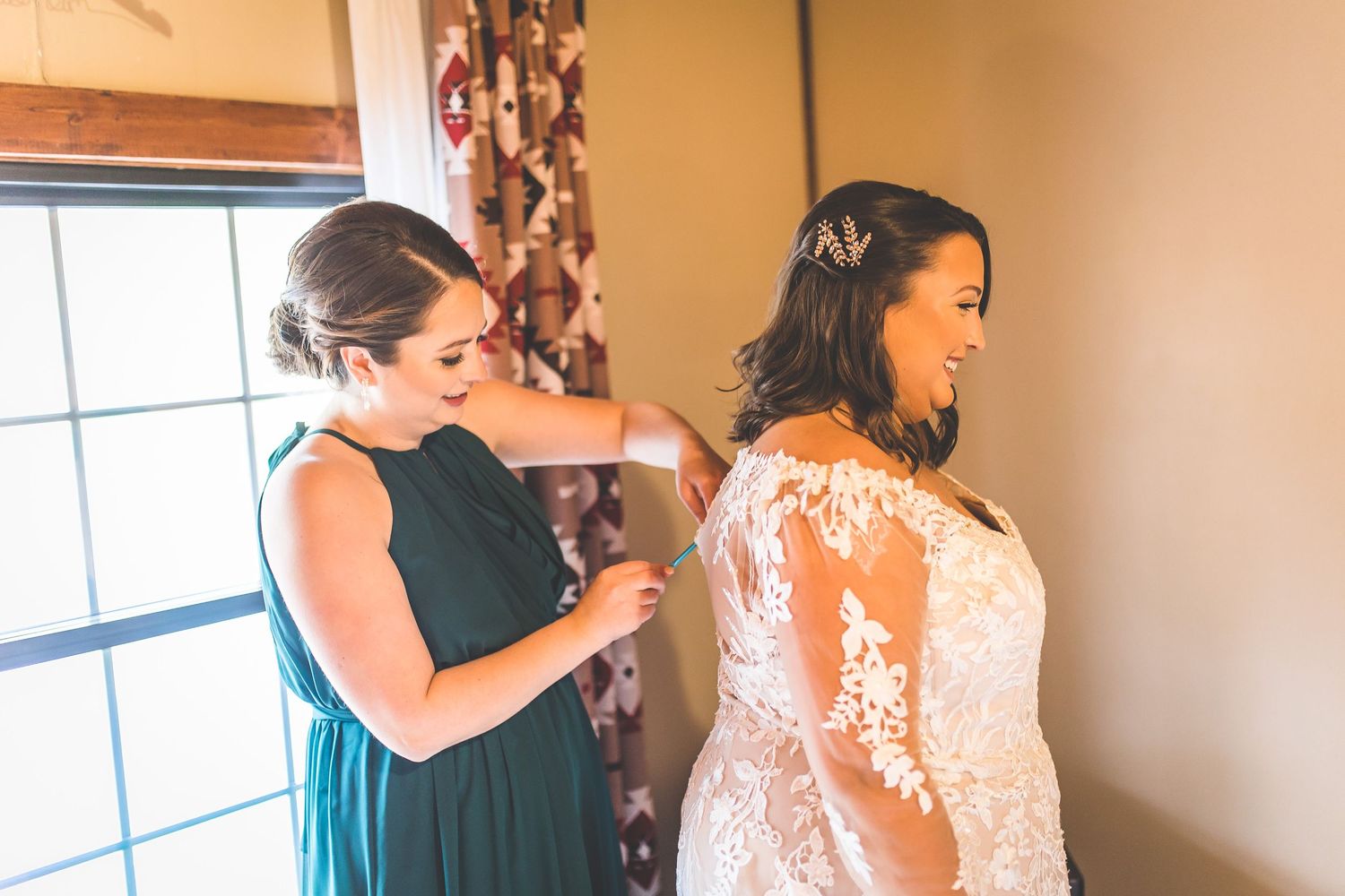 Final adjustments being made to a lace wedding dress during preparation.