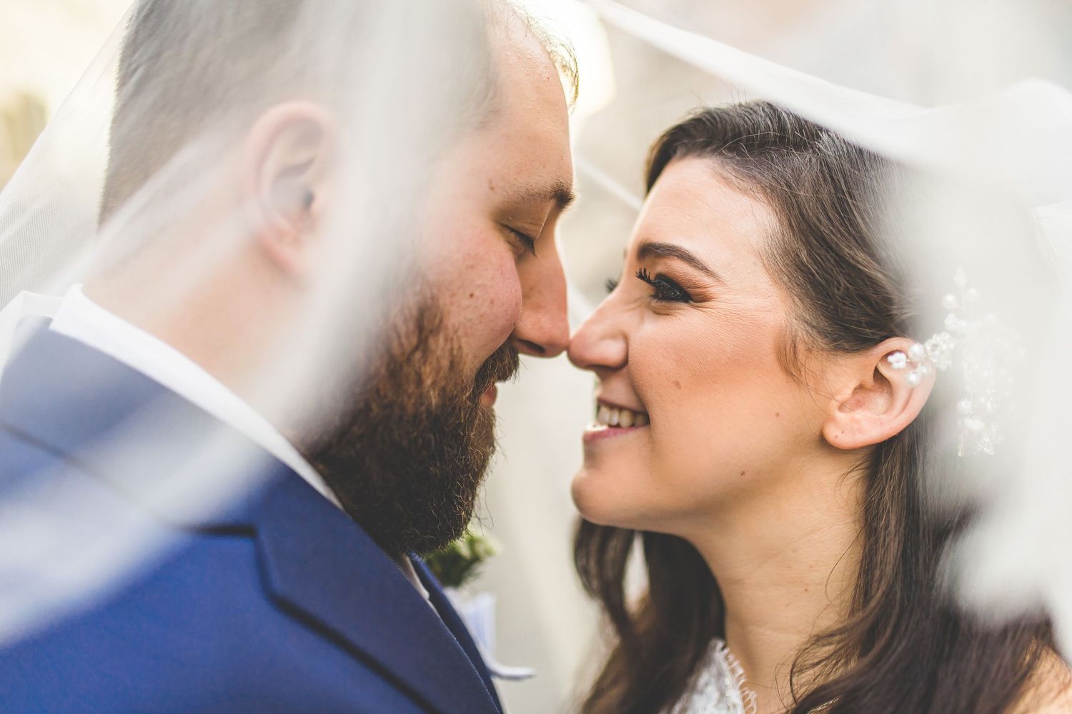 Romantic close-up shots of wedding couple sharing tender moments under bridal veil.