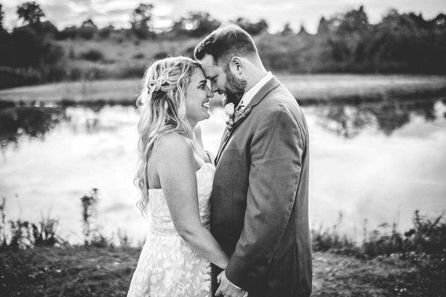 Black and white portrait of a romantic wedding moment by the water.