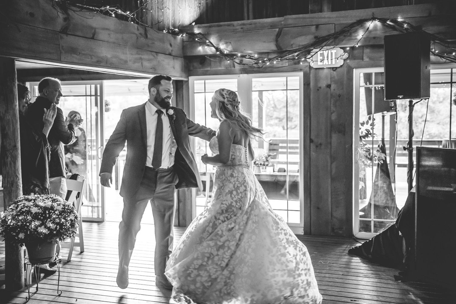 Black and white photos of wedding reception dancing in rustic barn venue.