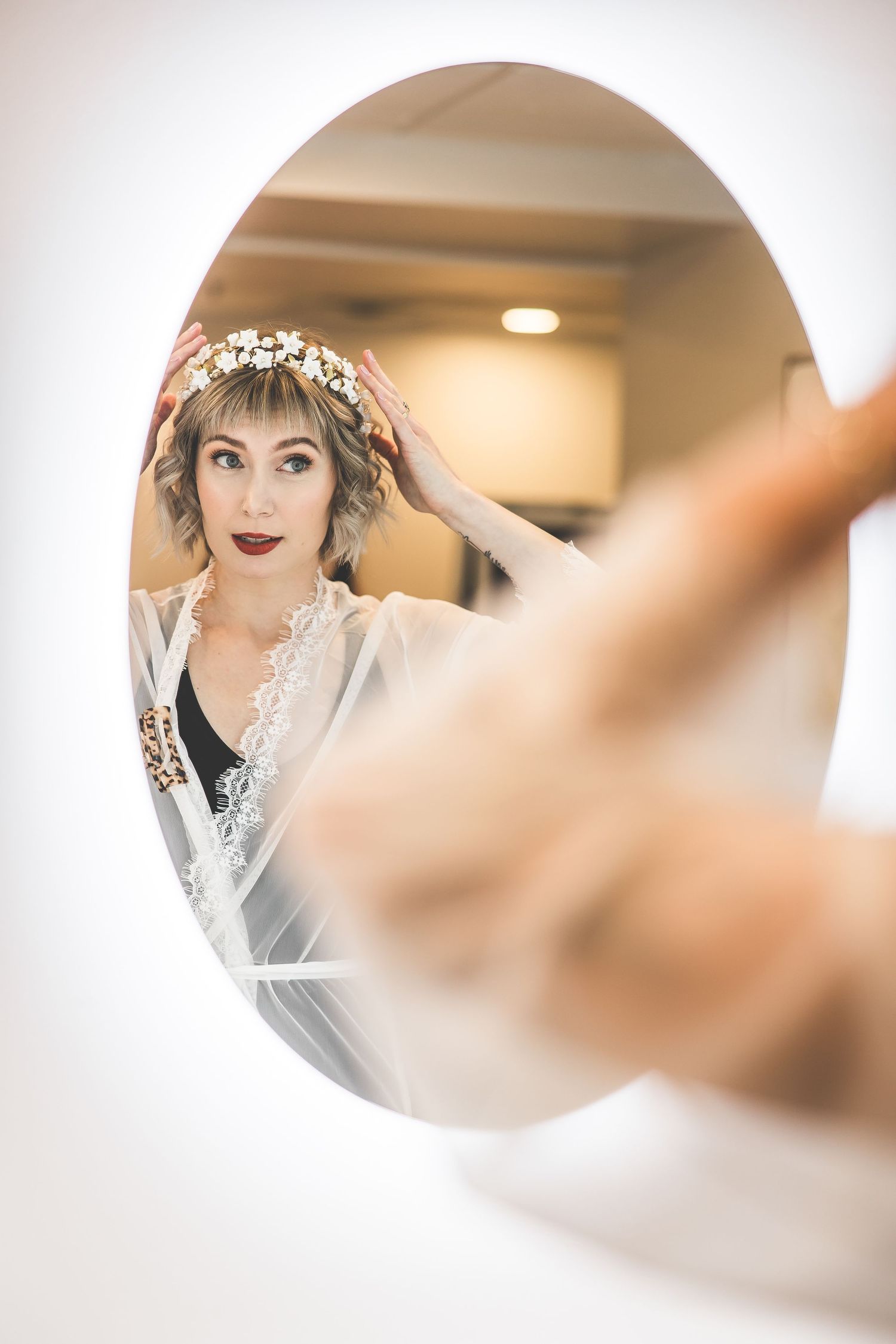 Artistic mirror reflection shot of bridal preparation with soft focus edges.