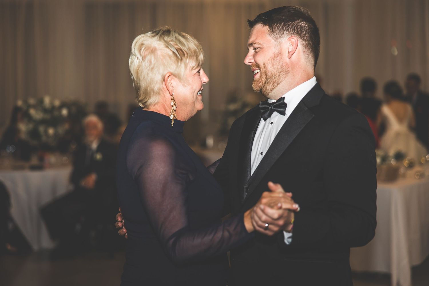Couples dancing together at an elegant indoor wedding reception.