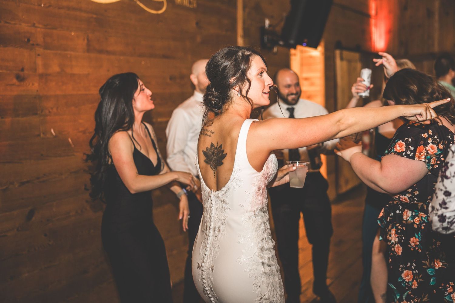 Lively dance floor moments at a rustic barn wedding reception.