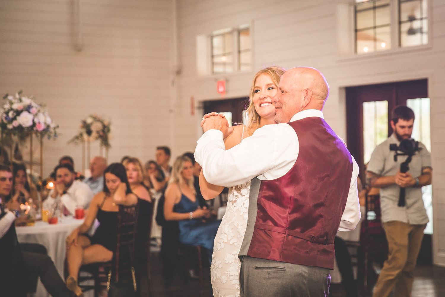 Wedding celebration with guests dancing and enjoying festivities in reception hall.