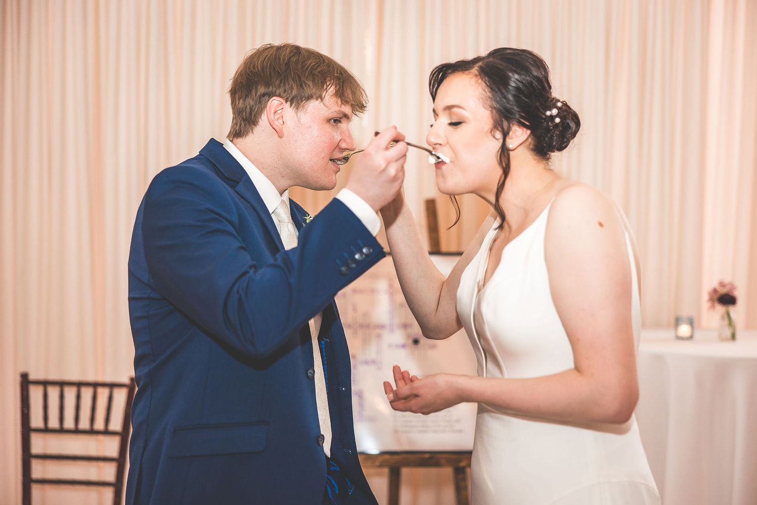 Newlyweds share cake during traditional wedding cake cutting ceremony.