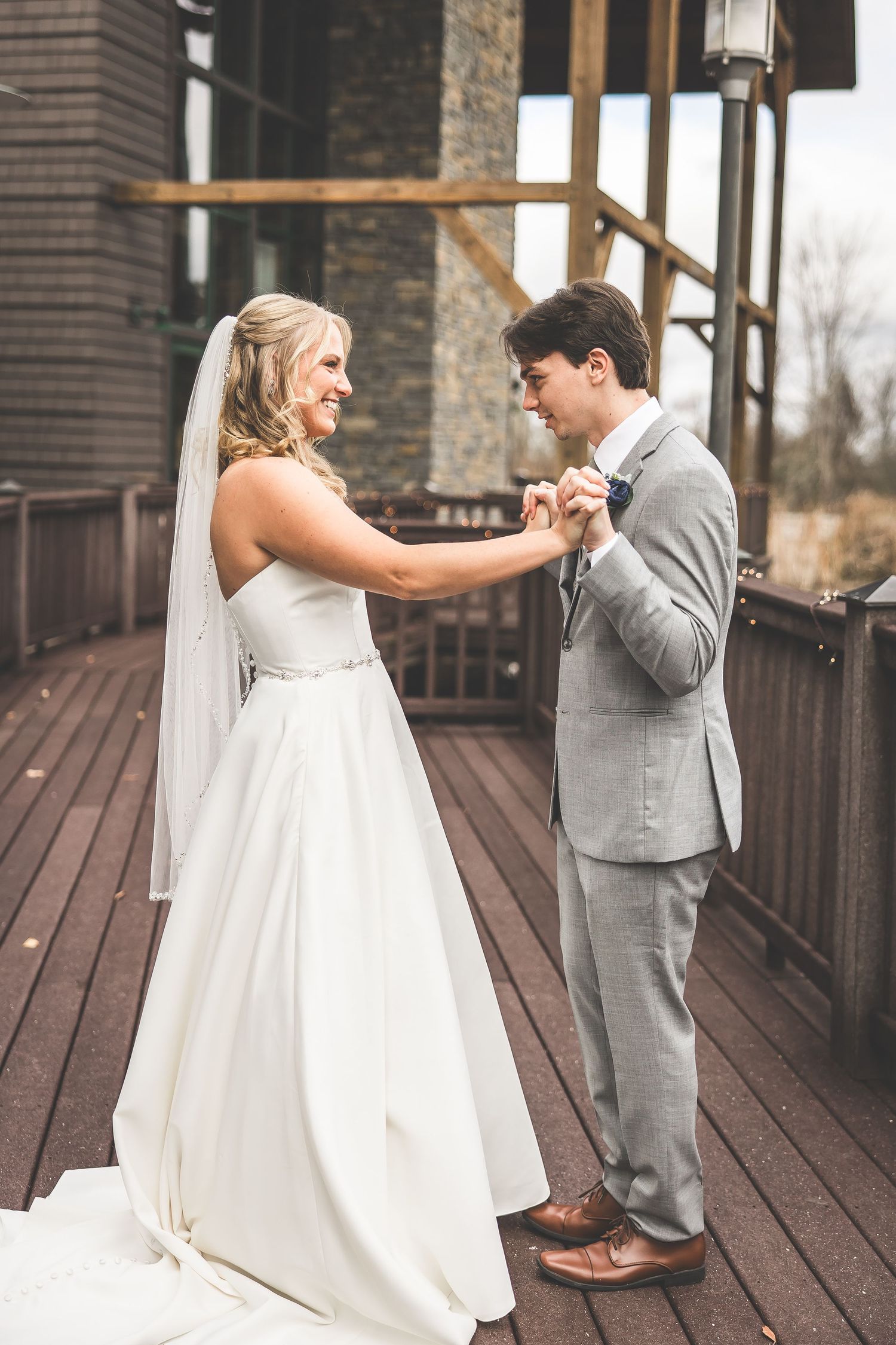 Wedding couple's emotional first look reaction on outdoor venue deck.