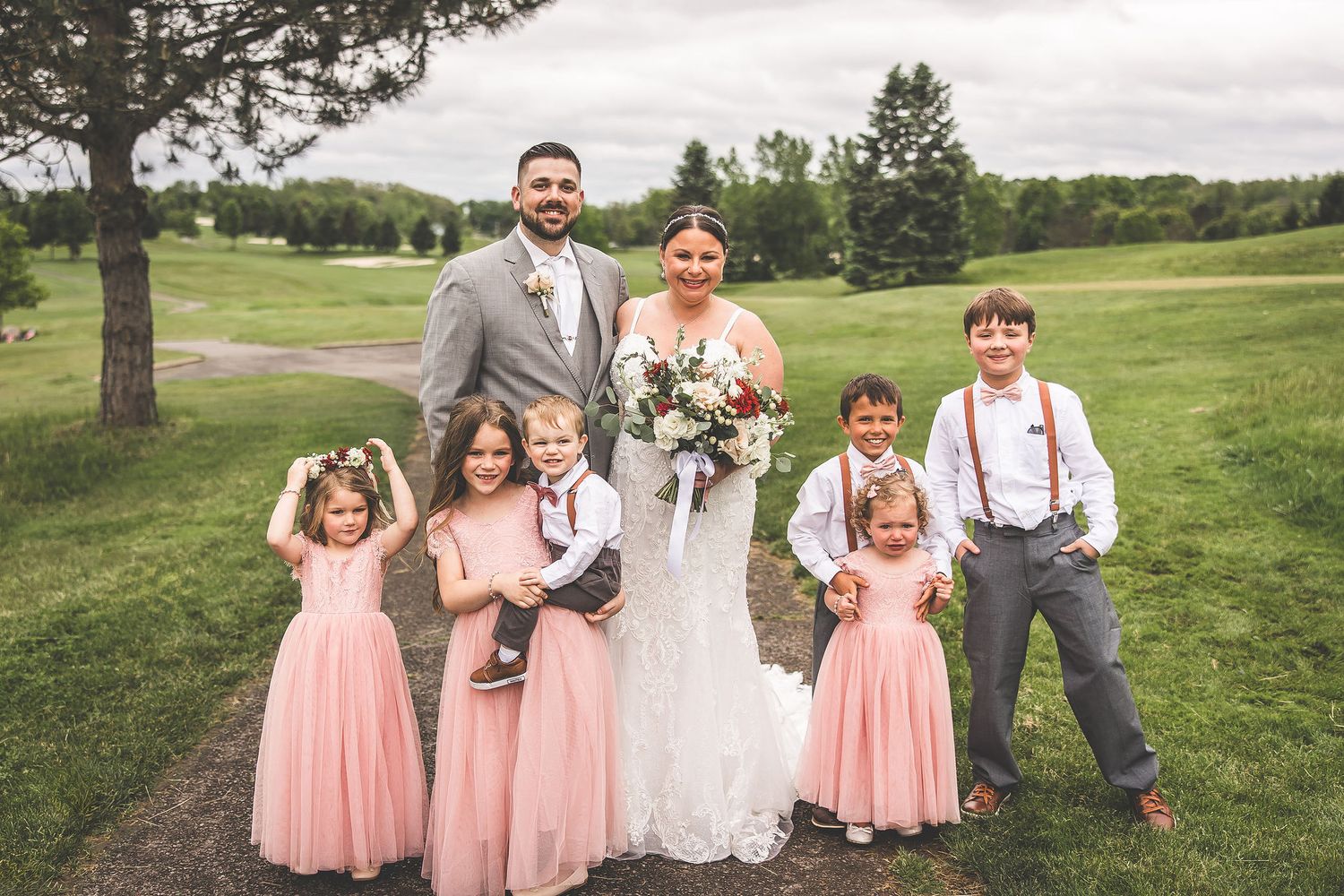 Wedding party members arrange themselves for casual outdoor group photos.