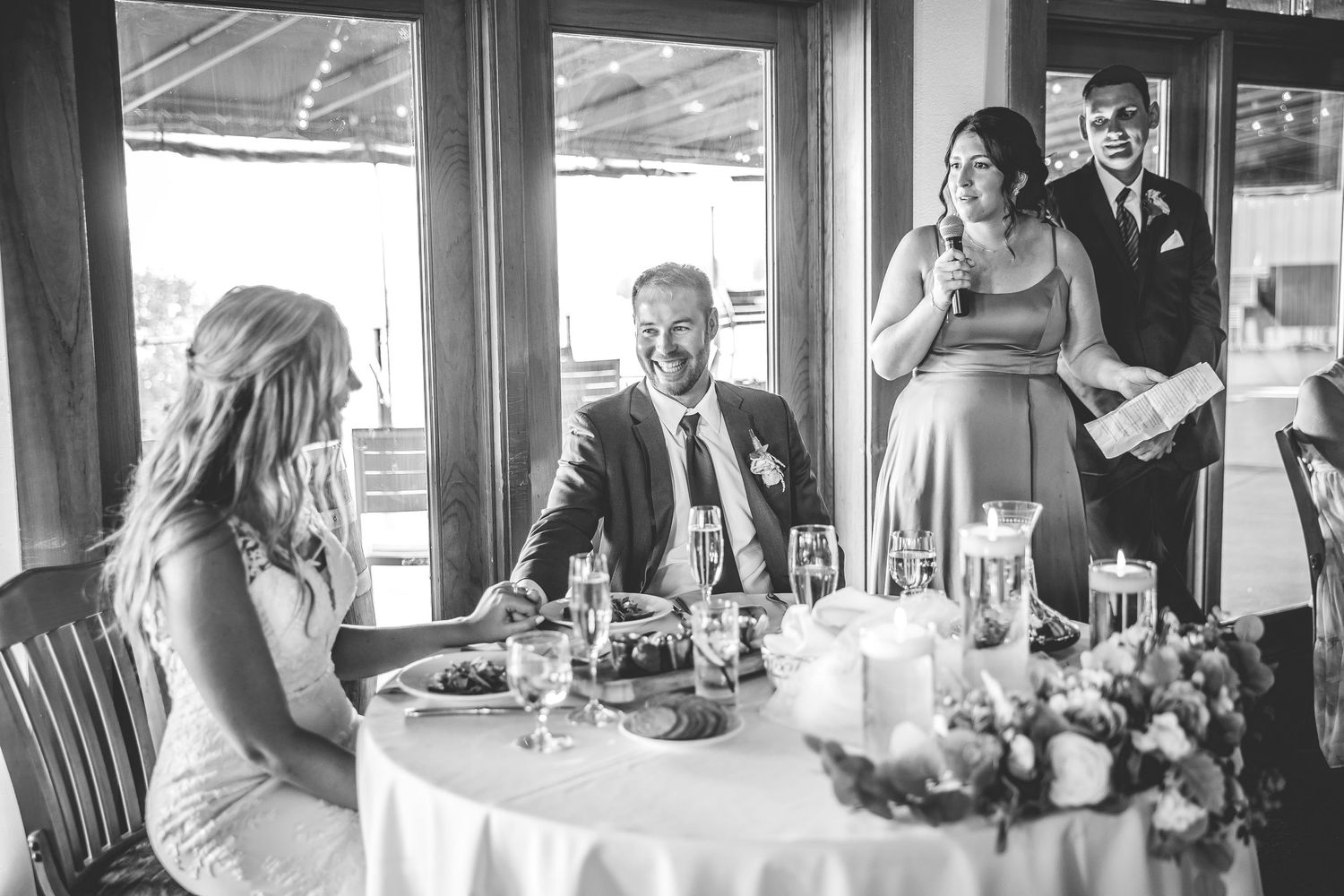 Panoramic view of wedding reception dining room with natural light streaming through windows.