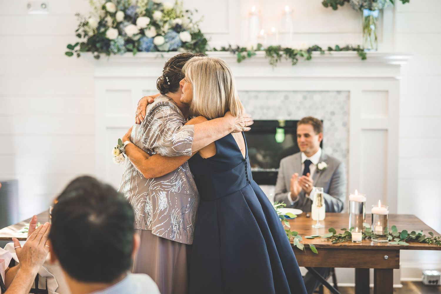 Wedding reception dining area with rustic wooden tables and floral decorations.