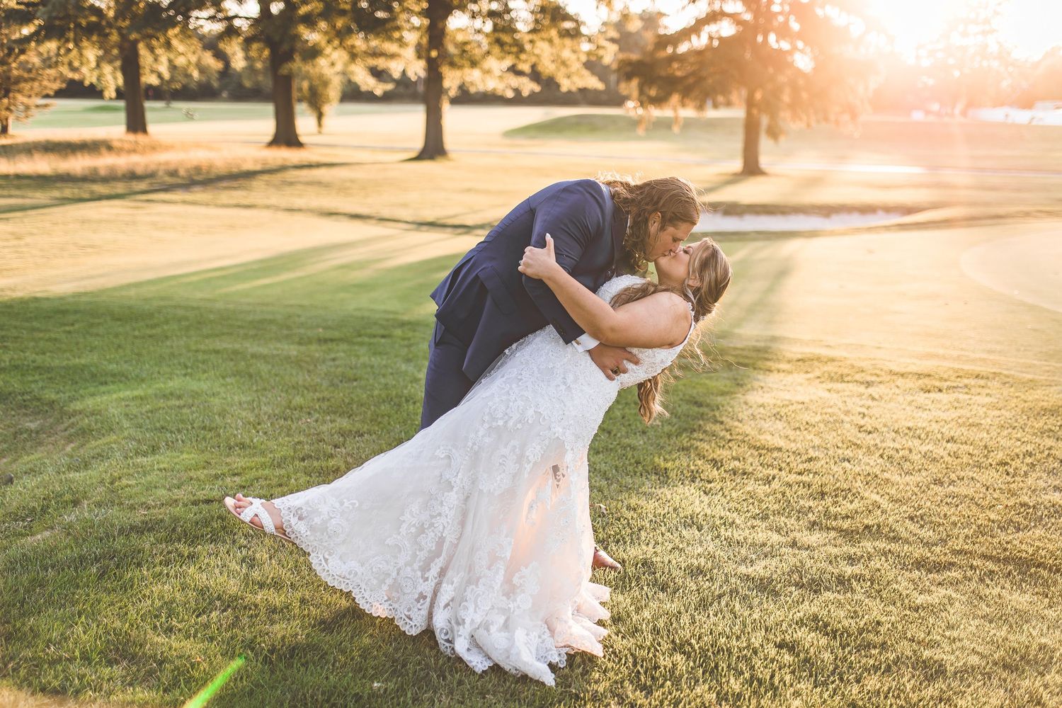 Romantic sunset dance on a grassy golf course with warm lighting.