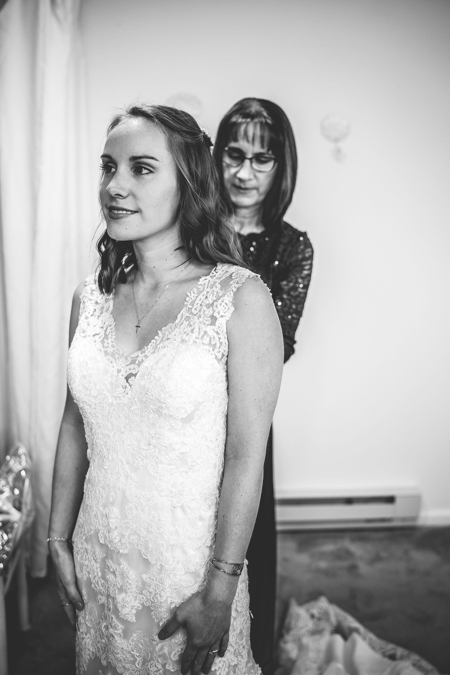 Black and white wedding preparation moment in indoor setting.