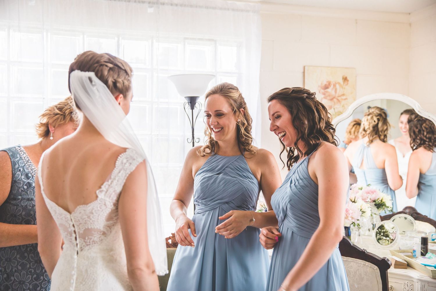 Getting ready scene with soft natural window light and flowing fabrics.