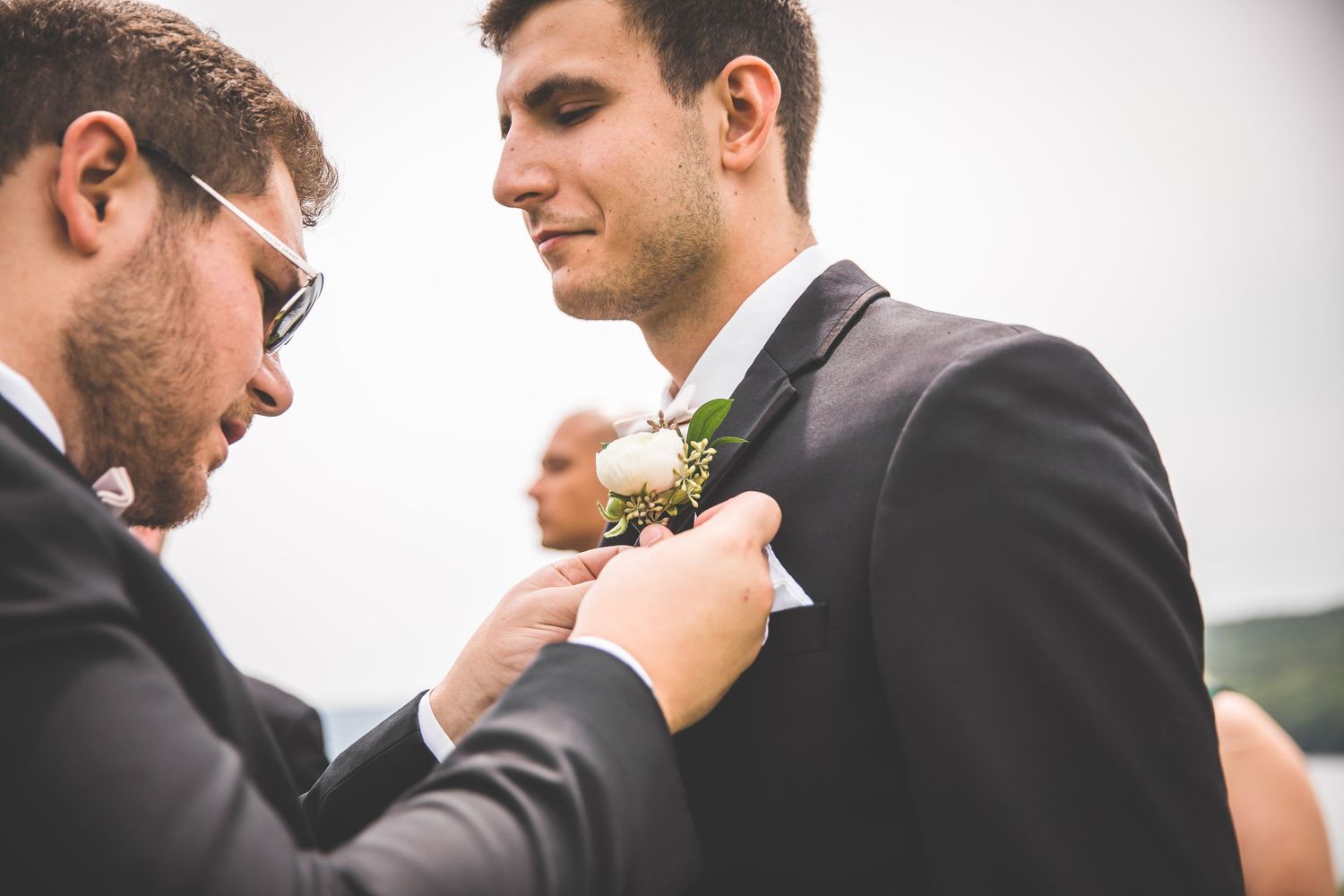 Groomsmen in black tuxedos prepare for wedding ceremony.