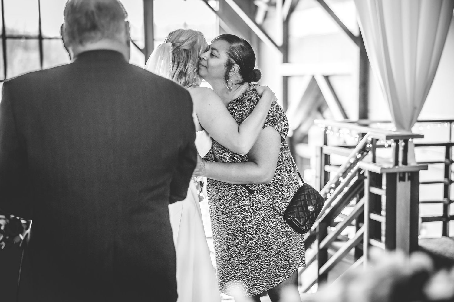 Black and white candid moments captured during indoor wedding reception.