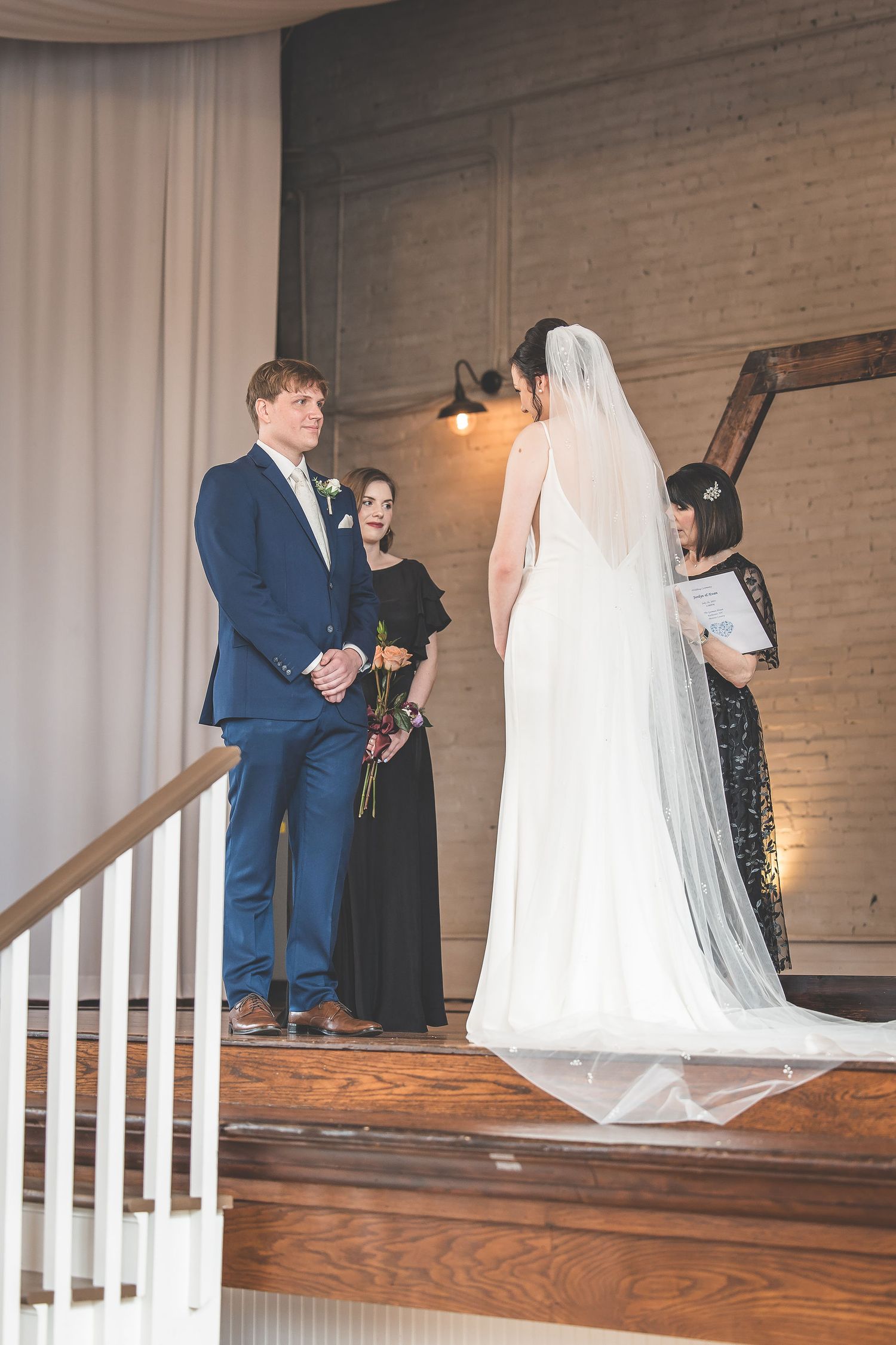 Wedding ceremony moments captured on rustic wooden stage with white curtain backdrop.