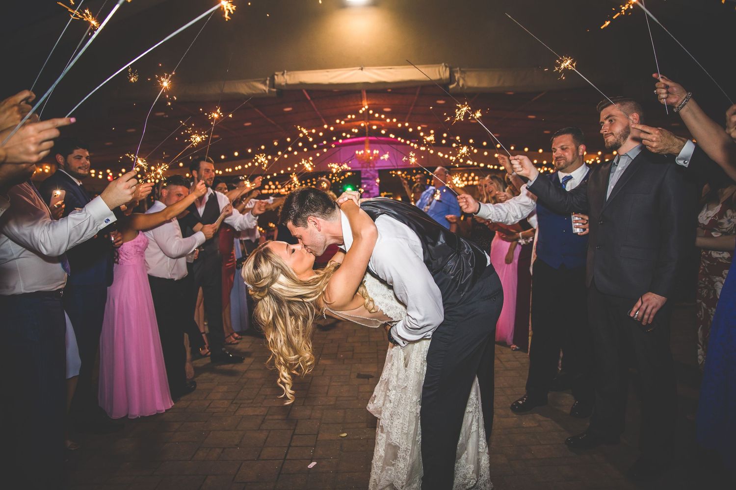 Wedding reception dance party with string lights creating a festive atmosphere.